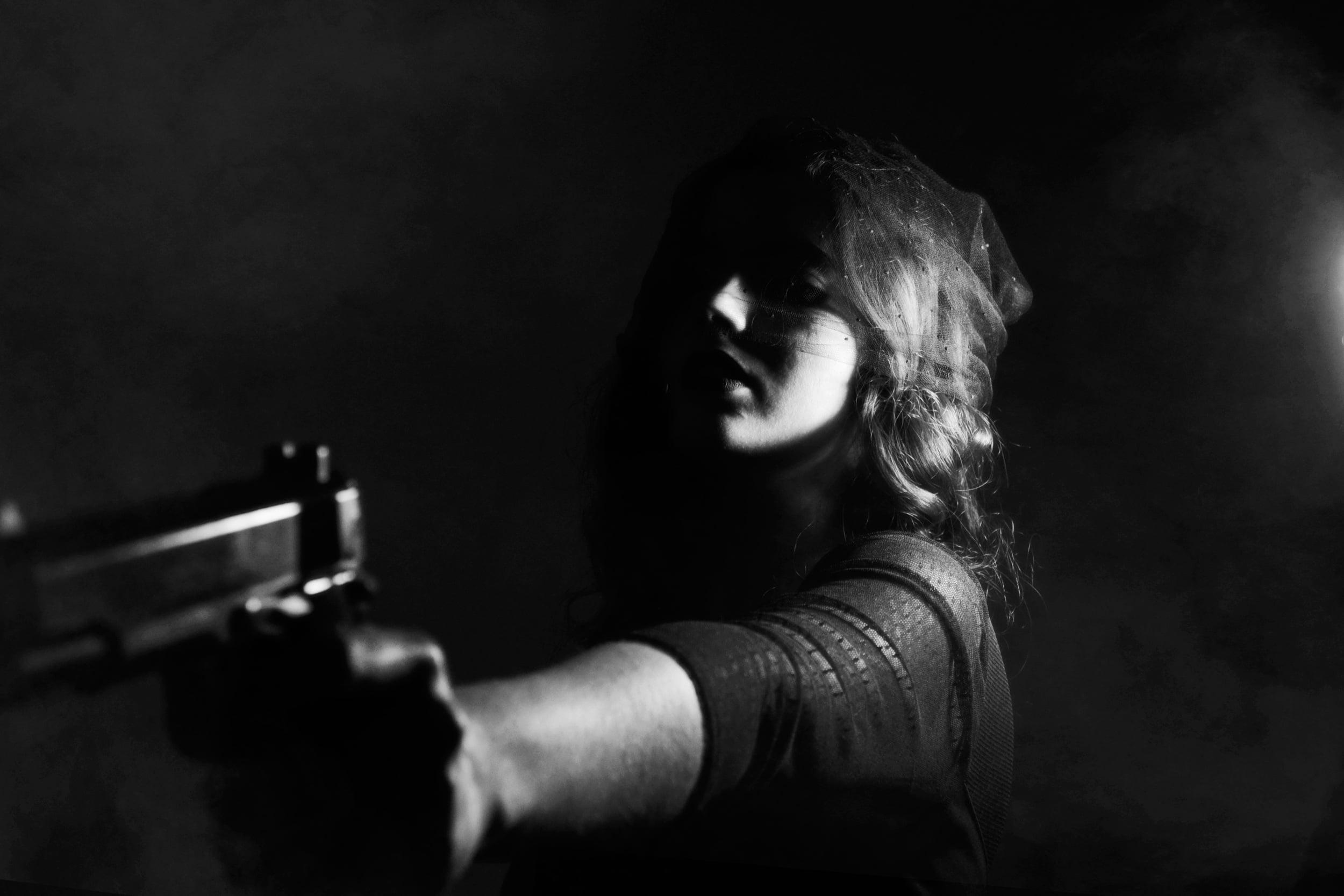 Grayscale photography of woman holding semi automatic pistol