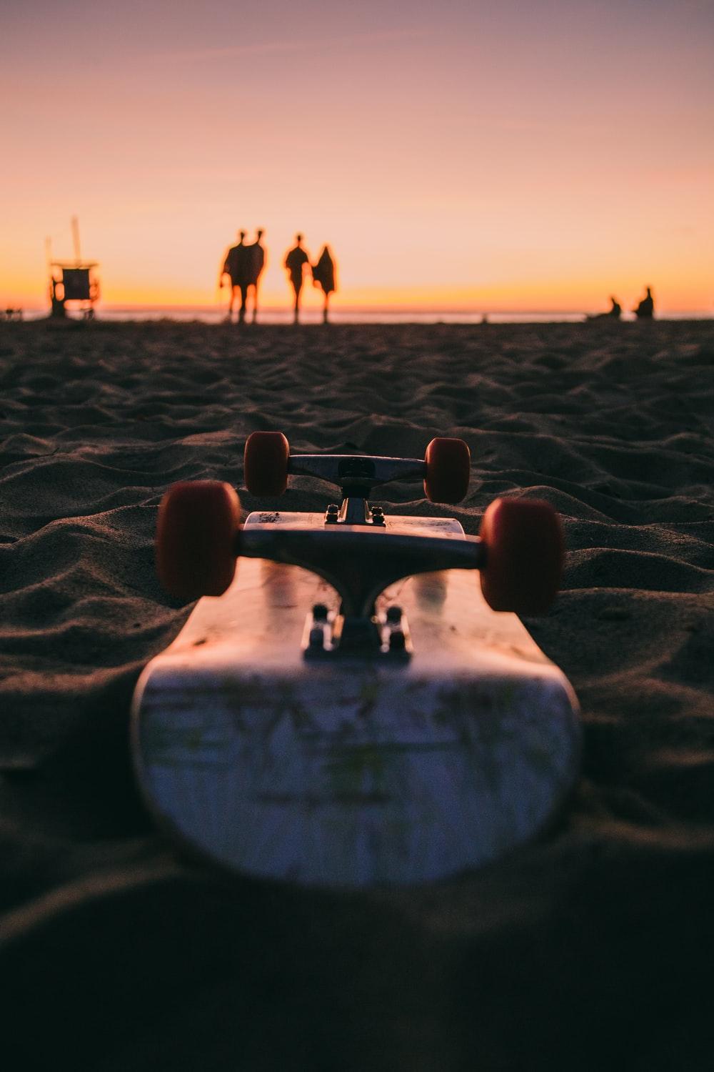 Close Up Photography Of Skateboard On Beach Sand Photo