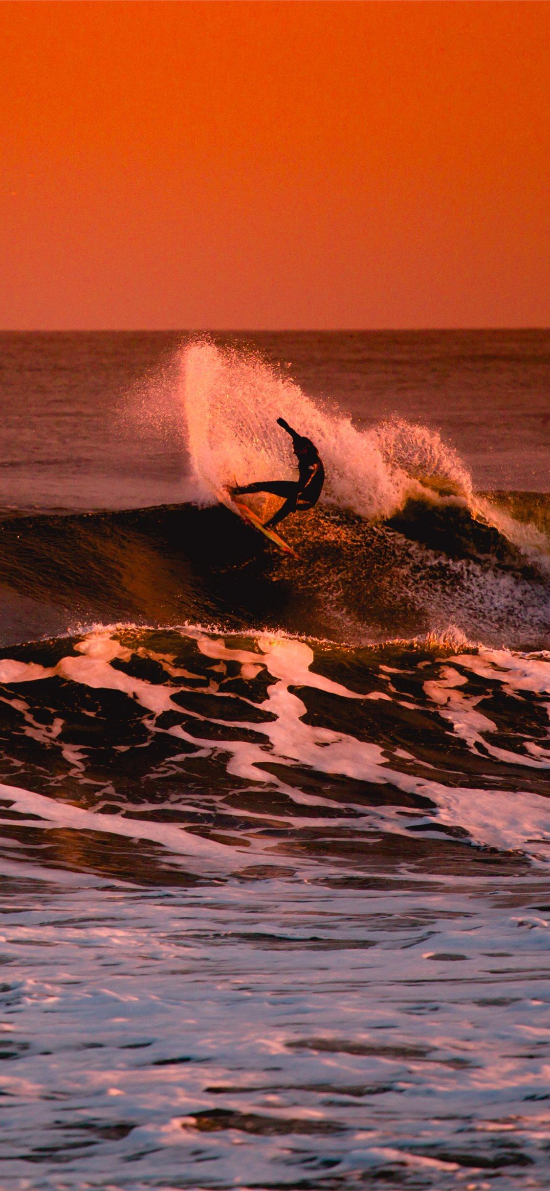 person surfing during sunset iPhone X Wallpaper Free Download