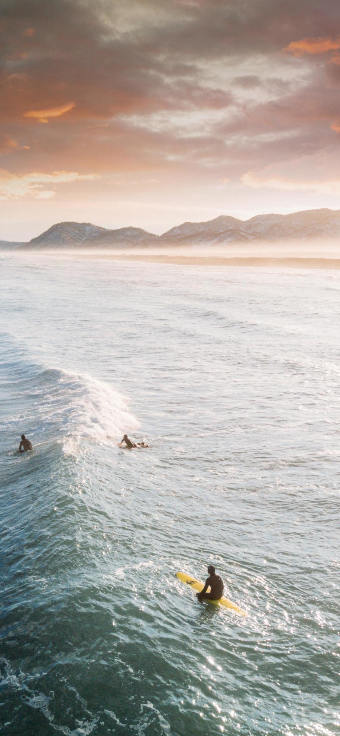 Download 1125x2436 wallpaper tide, surfers, sea, aerial shot