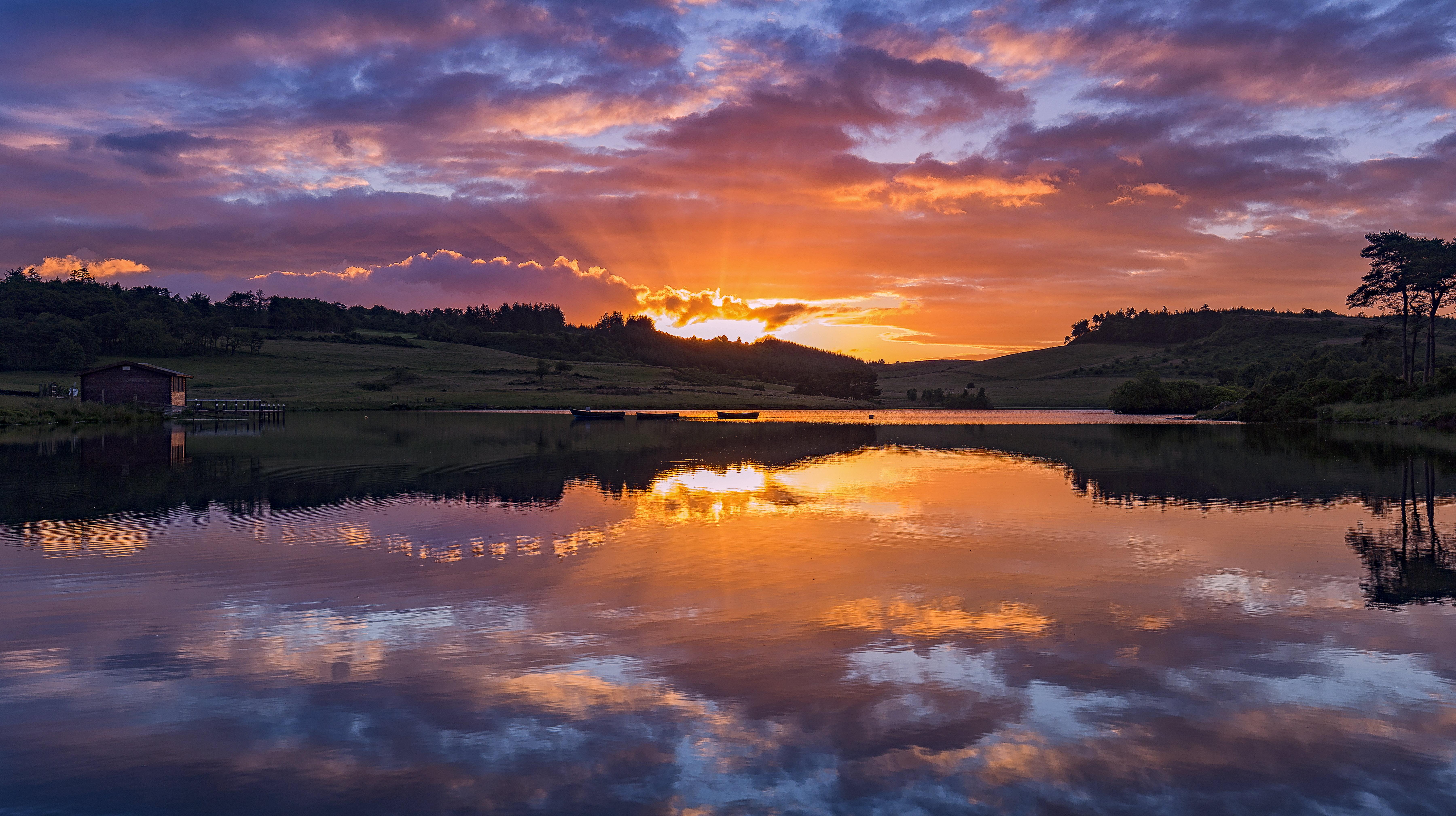 Silhouette of mountain with body of water at sunset HD