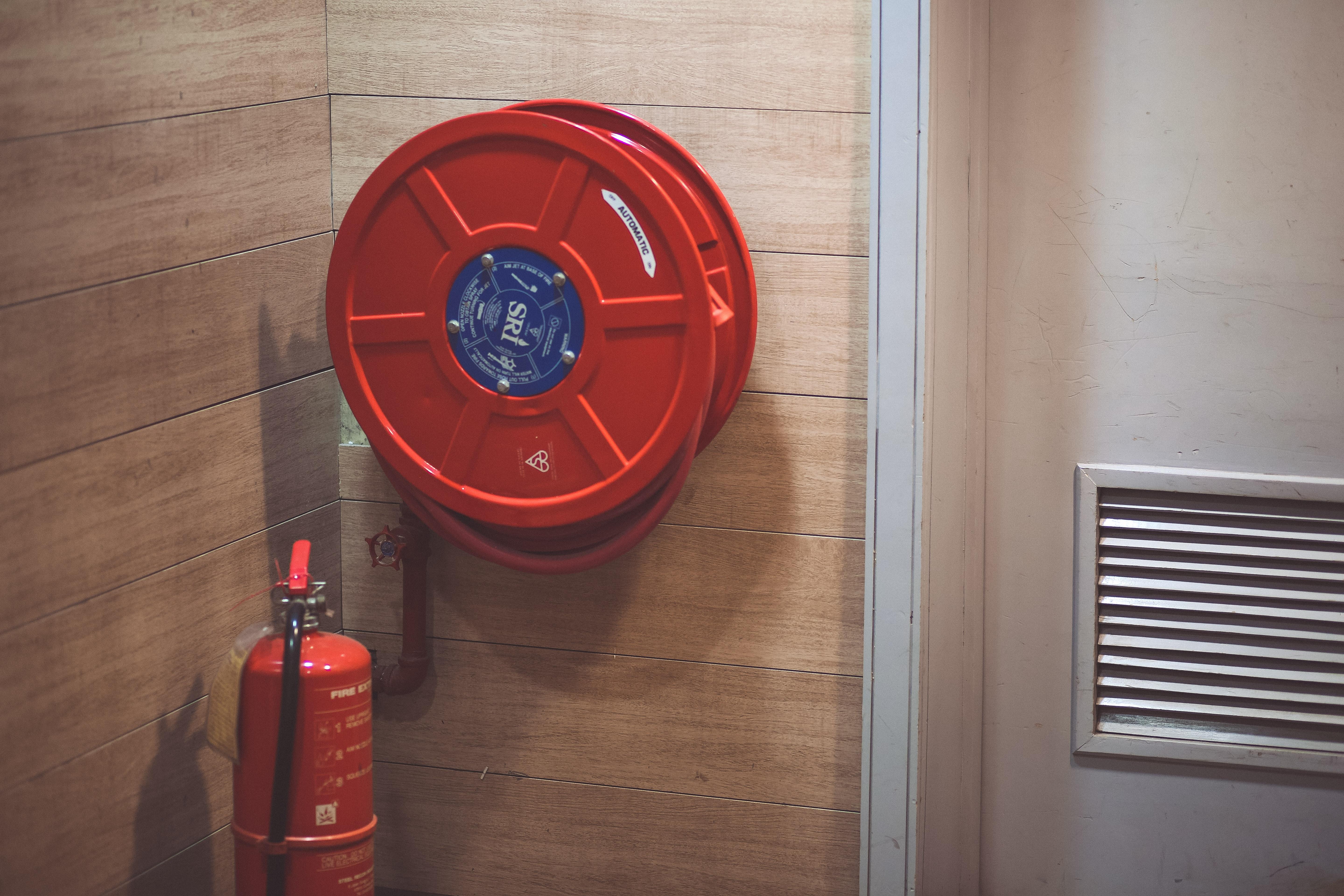 Red Fire Extinguisher Beside Hose Reel Inside the Room · Free