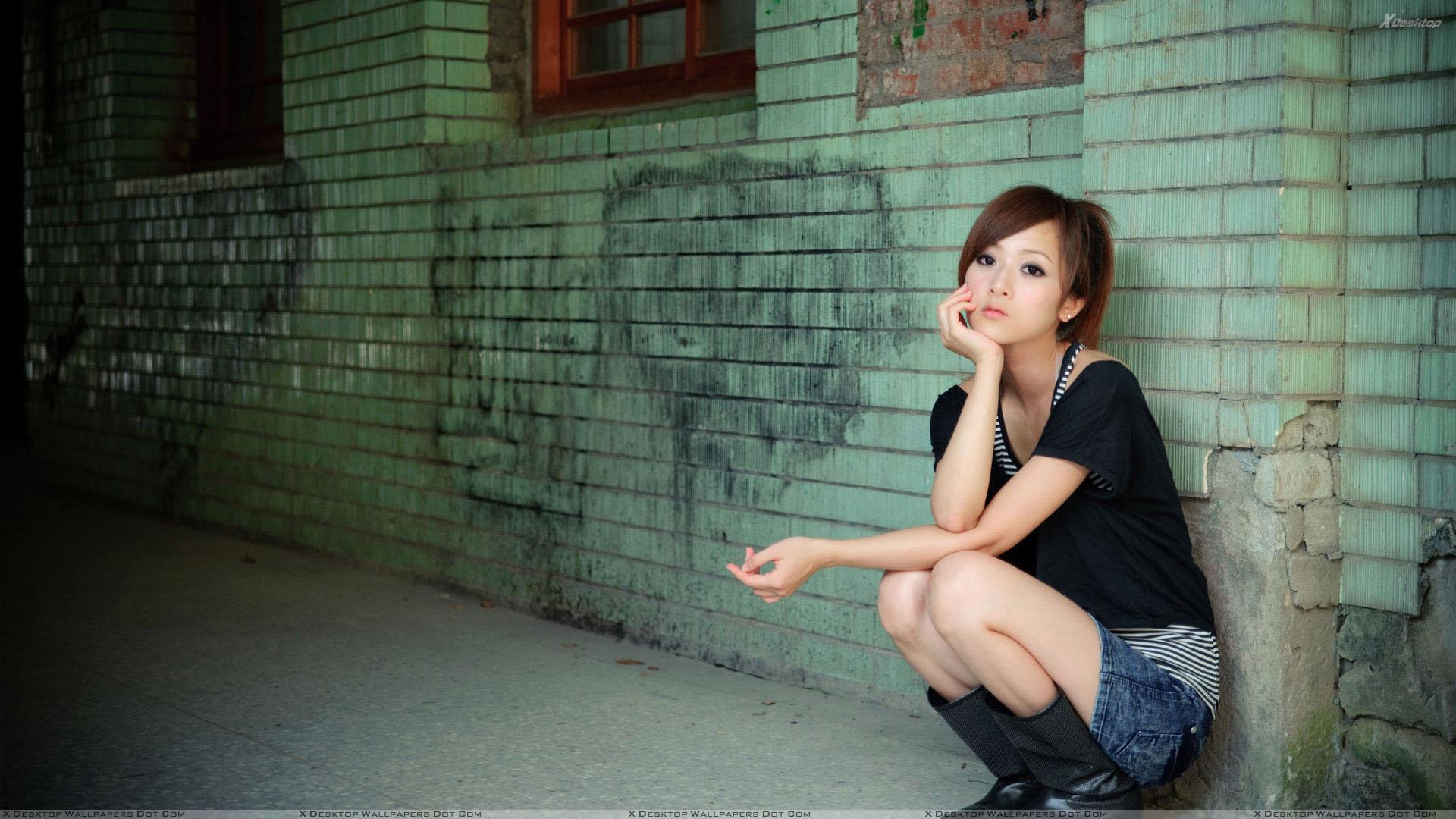 Asian Girl Sitting Pose Outside Metro Station Wallpaper
