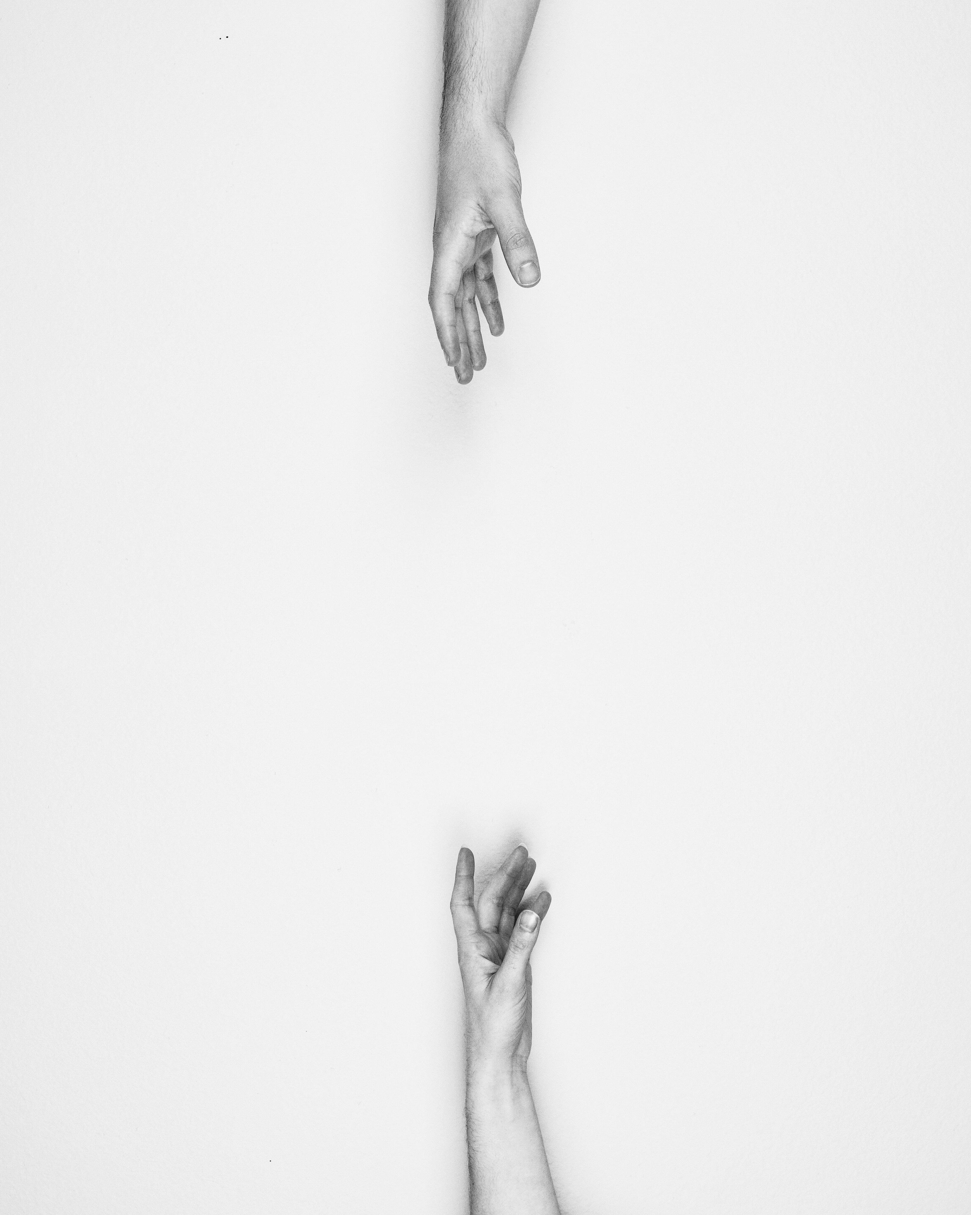 Two hands reaching each other in gray scale photo HD wallpaper