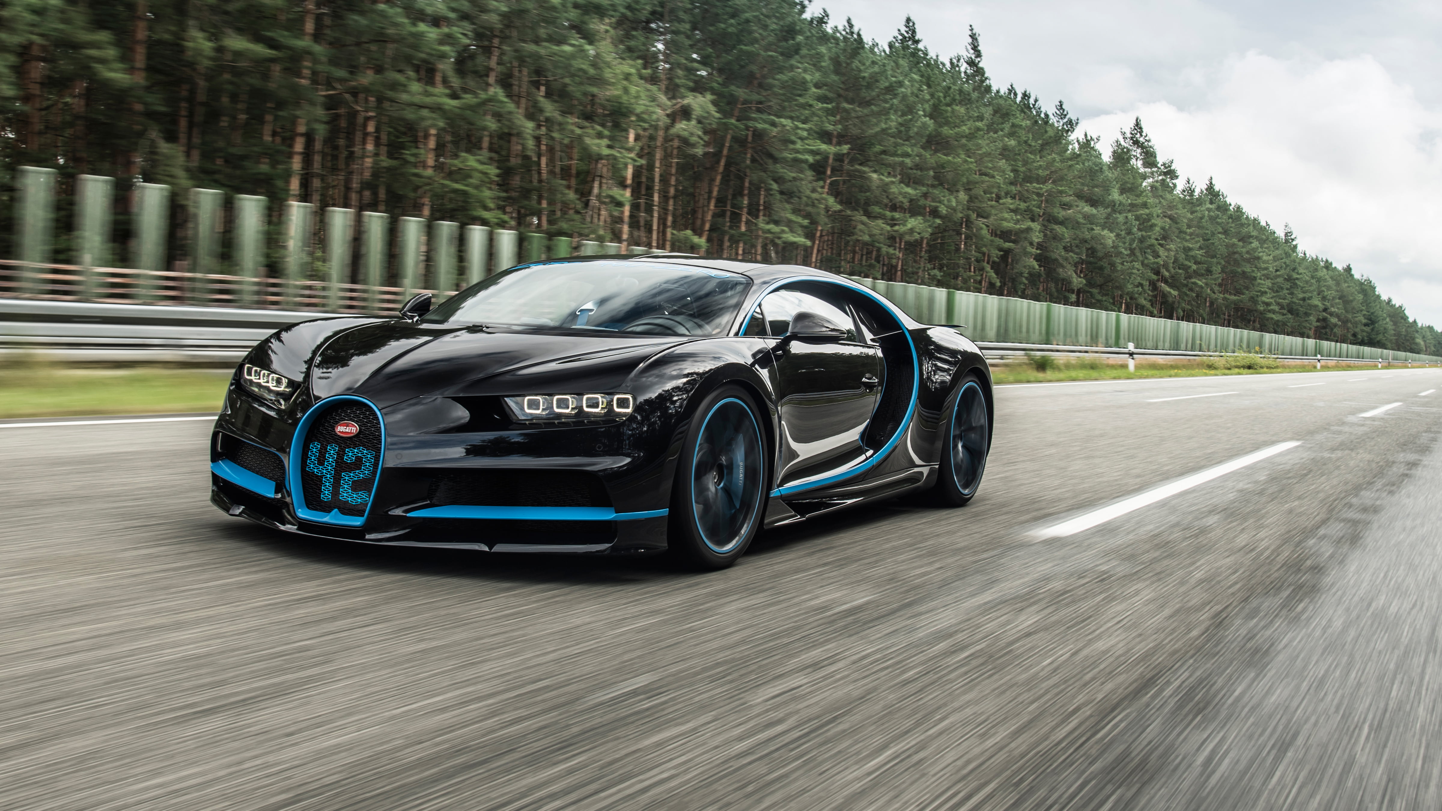 Black Bugatti Veyron running fast on gray concrete road during