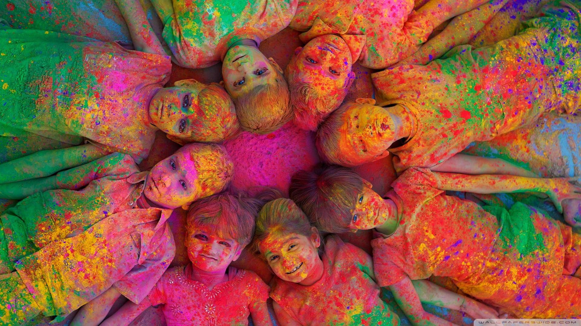 Painted children lying on ground, holi festival, colorful