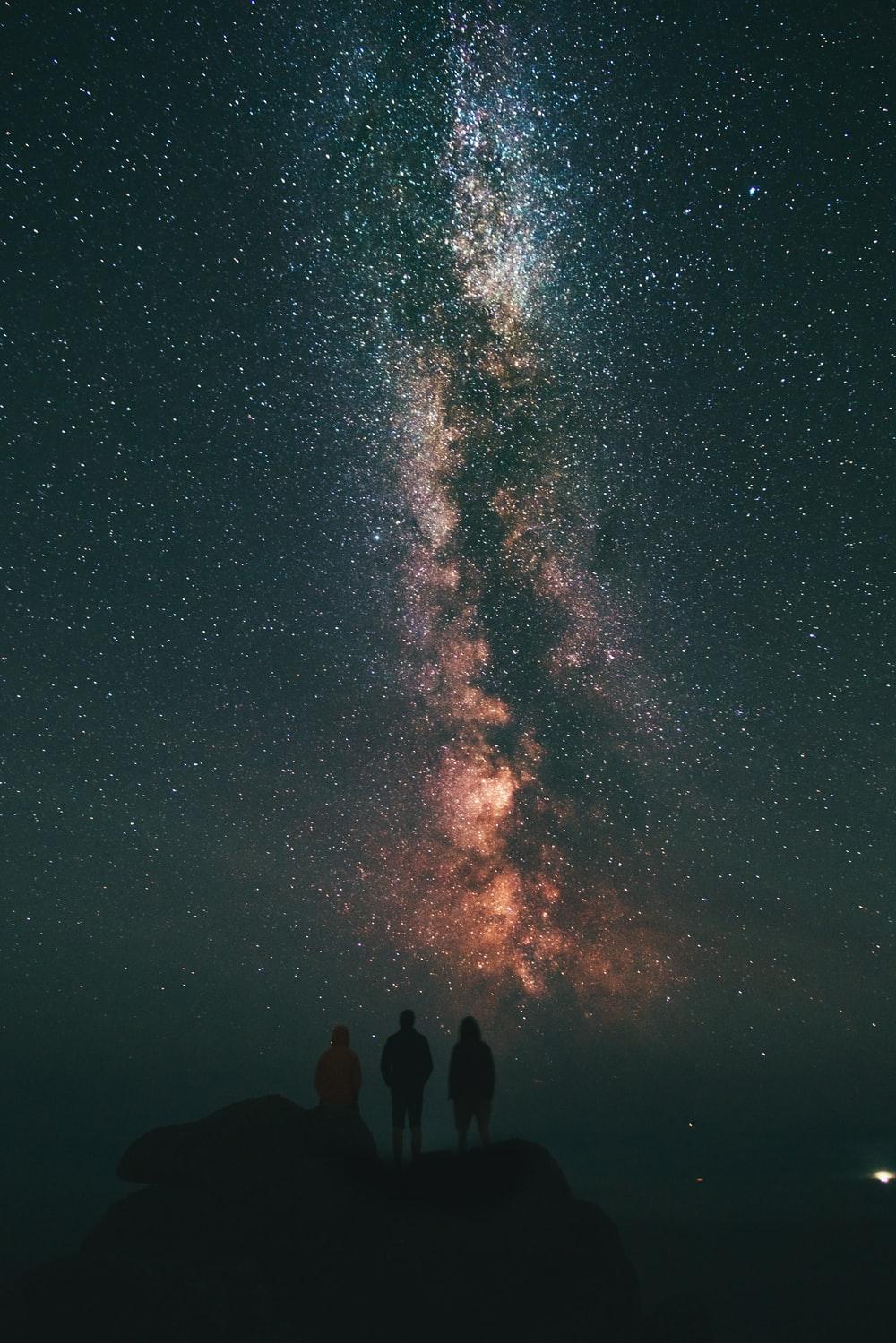 three person looking stars and milky way photo