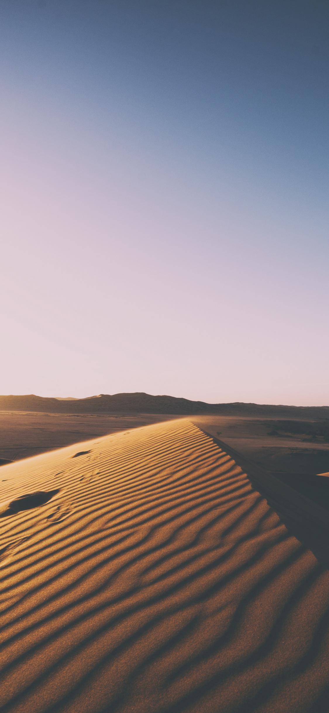 Download 1125x2436 wallpaper desert, sunset, clean skyline, sand
