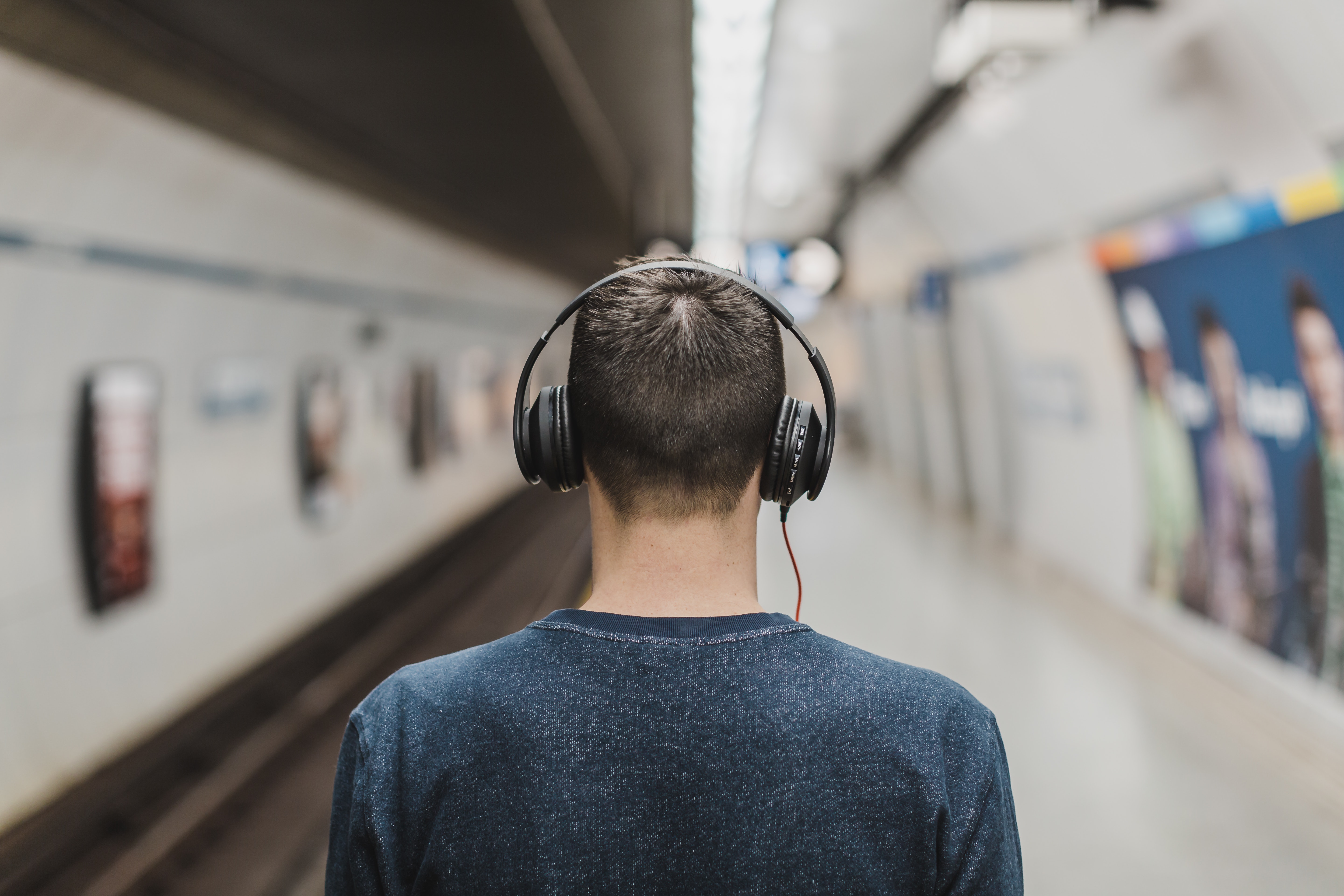 Man Wearing Black Headphones Beside Train Rail · Free