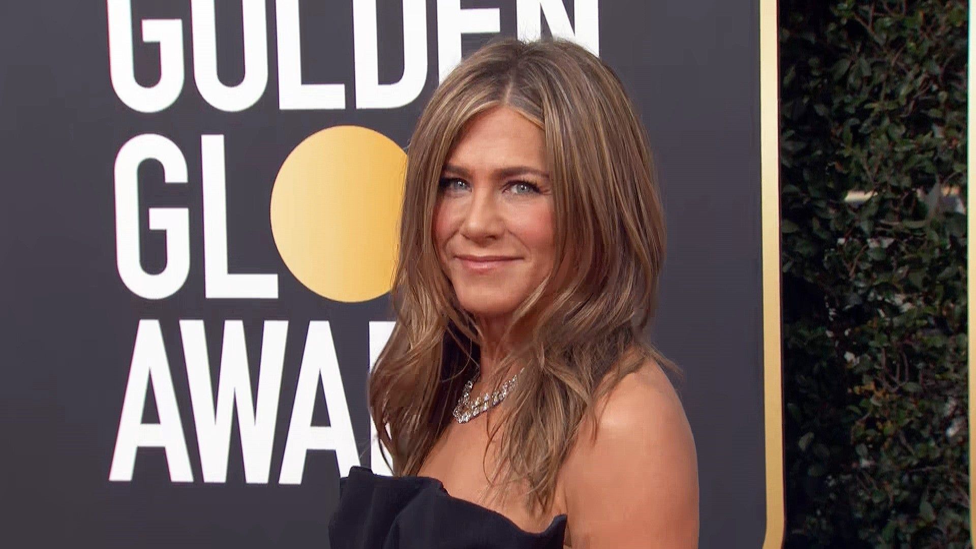 Jennifer Aniston Rocks Signature Look in Black Strapless Gown at