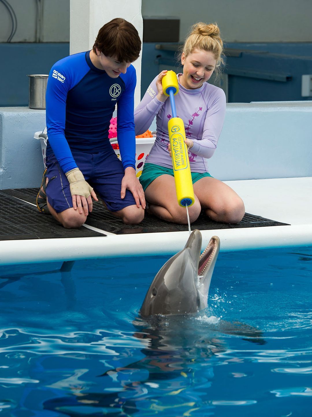Nathan Gamble (left) and Cozi Zuehlsdorff (right) feeding dolphin