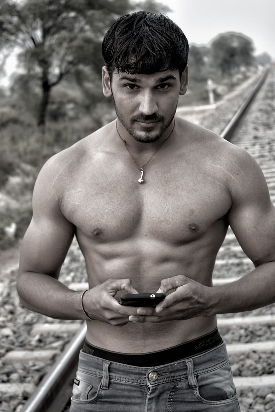 HD wallpaper: grayscale photo of man holding smartphone, traps