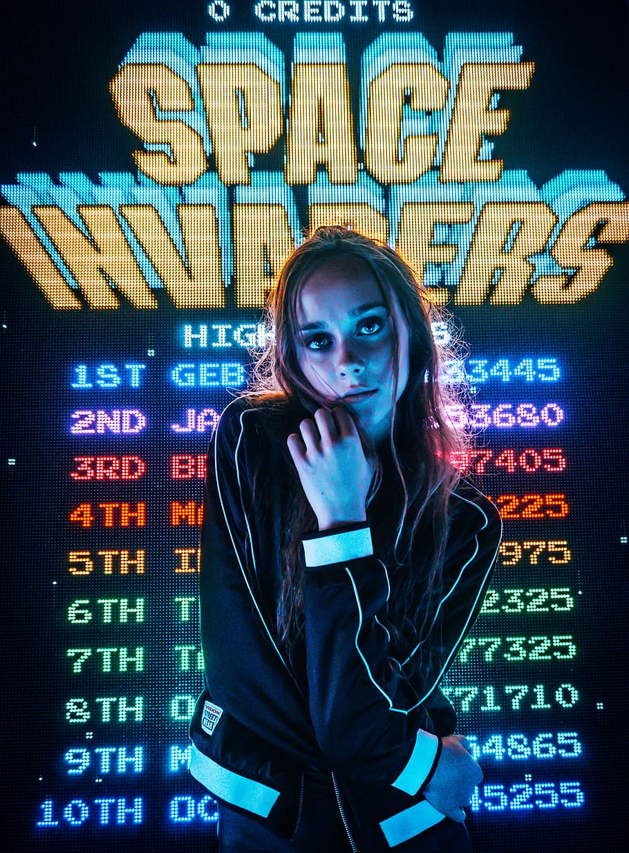 HD wallpaper: woman posing for photo in front of Space Invaders