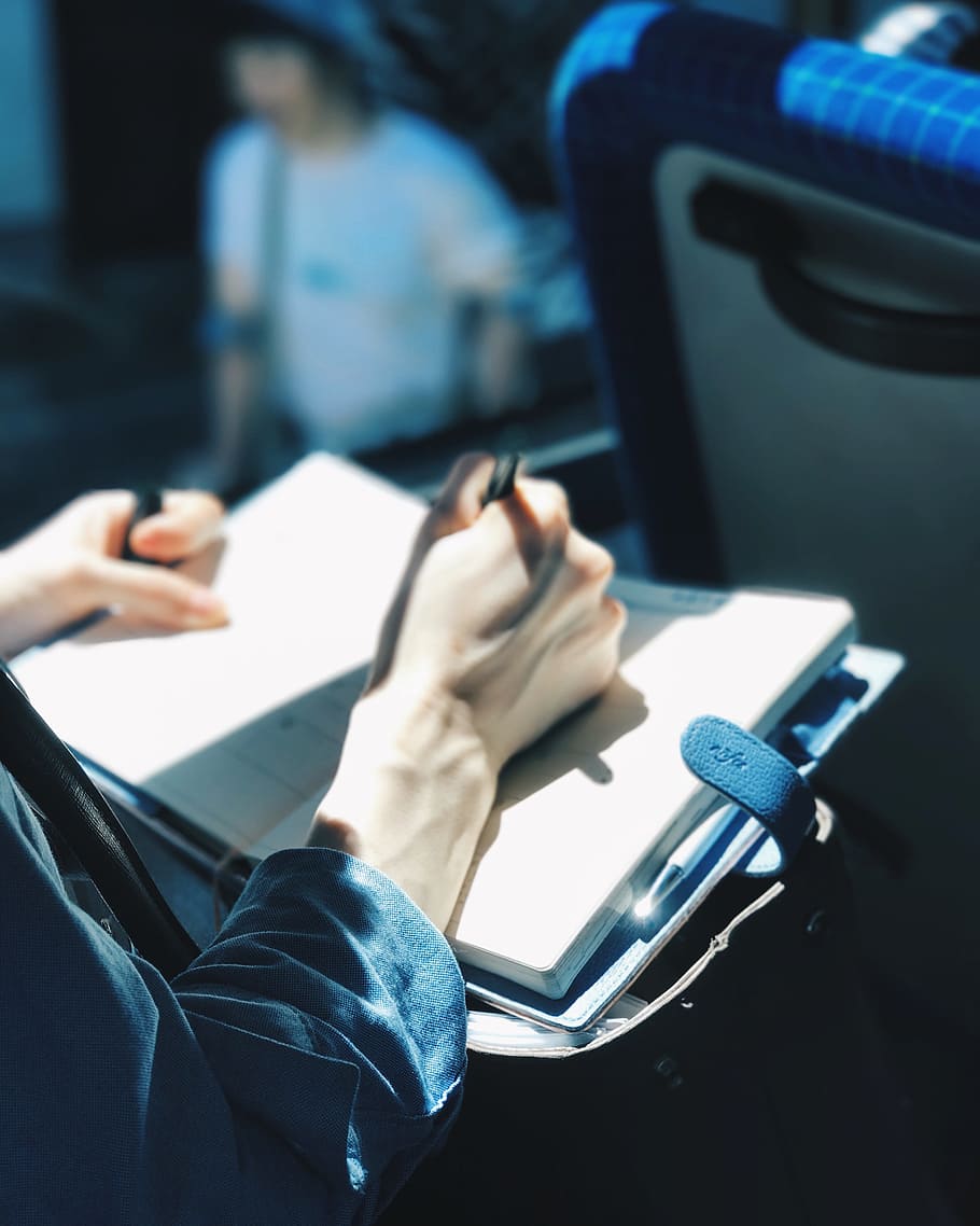 HD wallpaper: shallow focus photography of person writing on book
