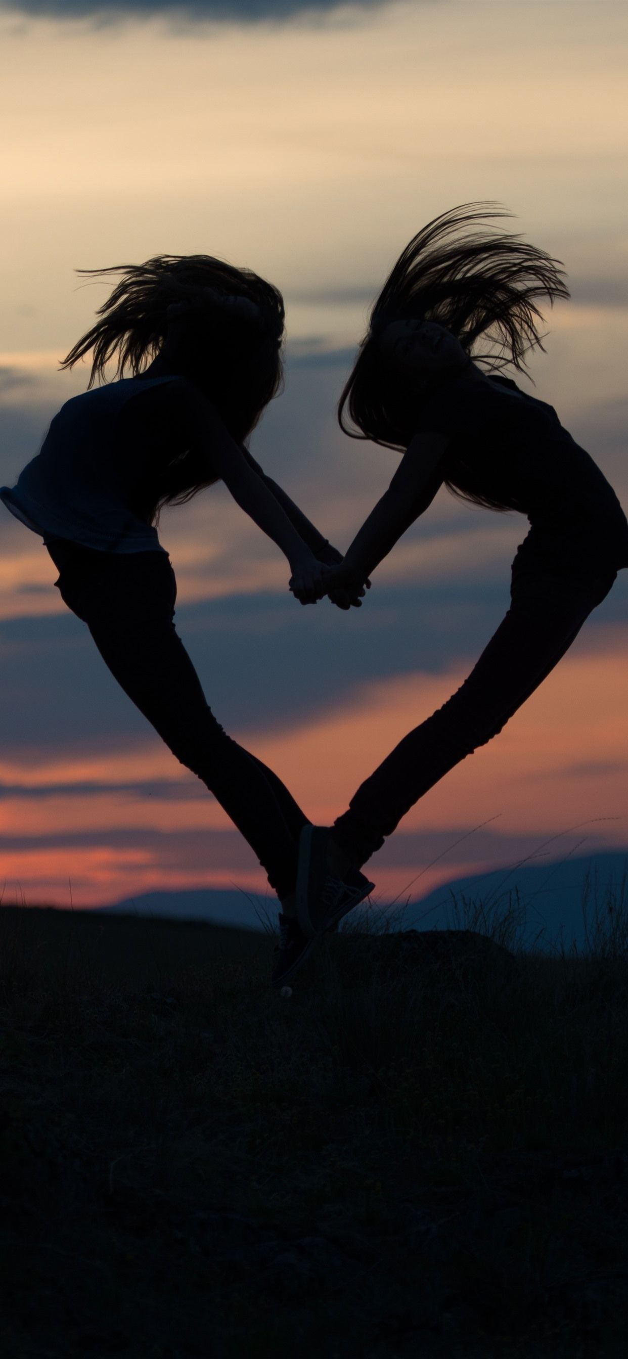 Two girls jump, love heart shaped, silhouette 1242x2688 iPhone 11