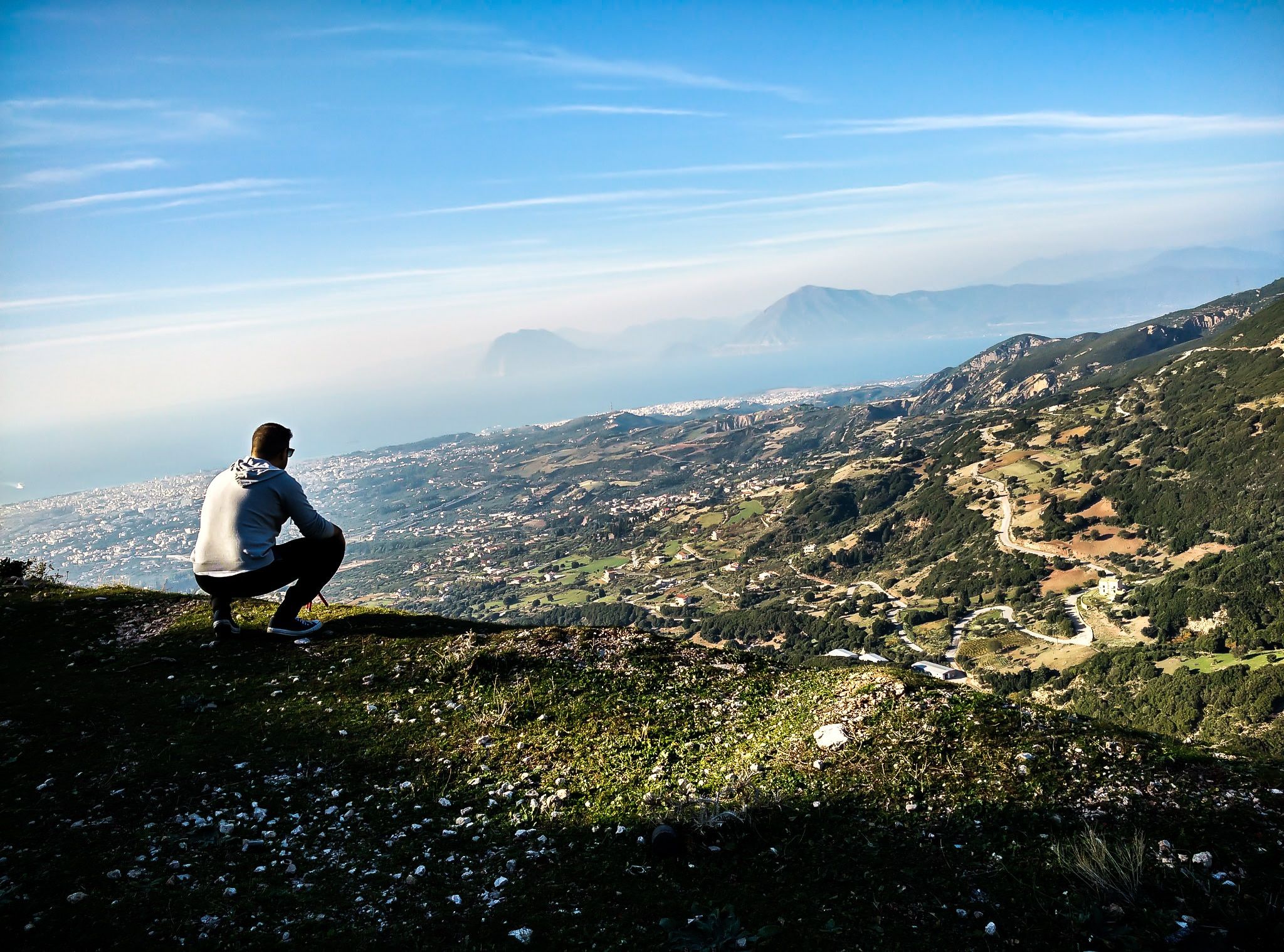 man sitting on the edge of a mountain free image