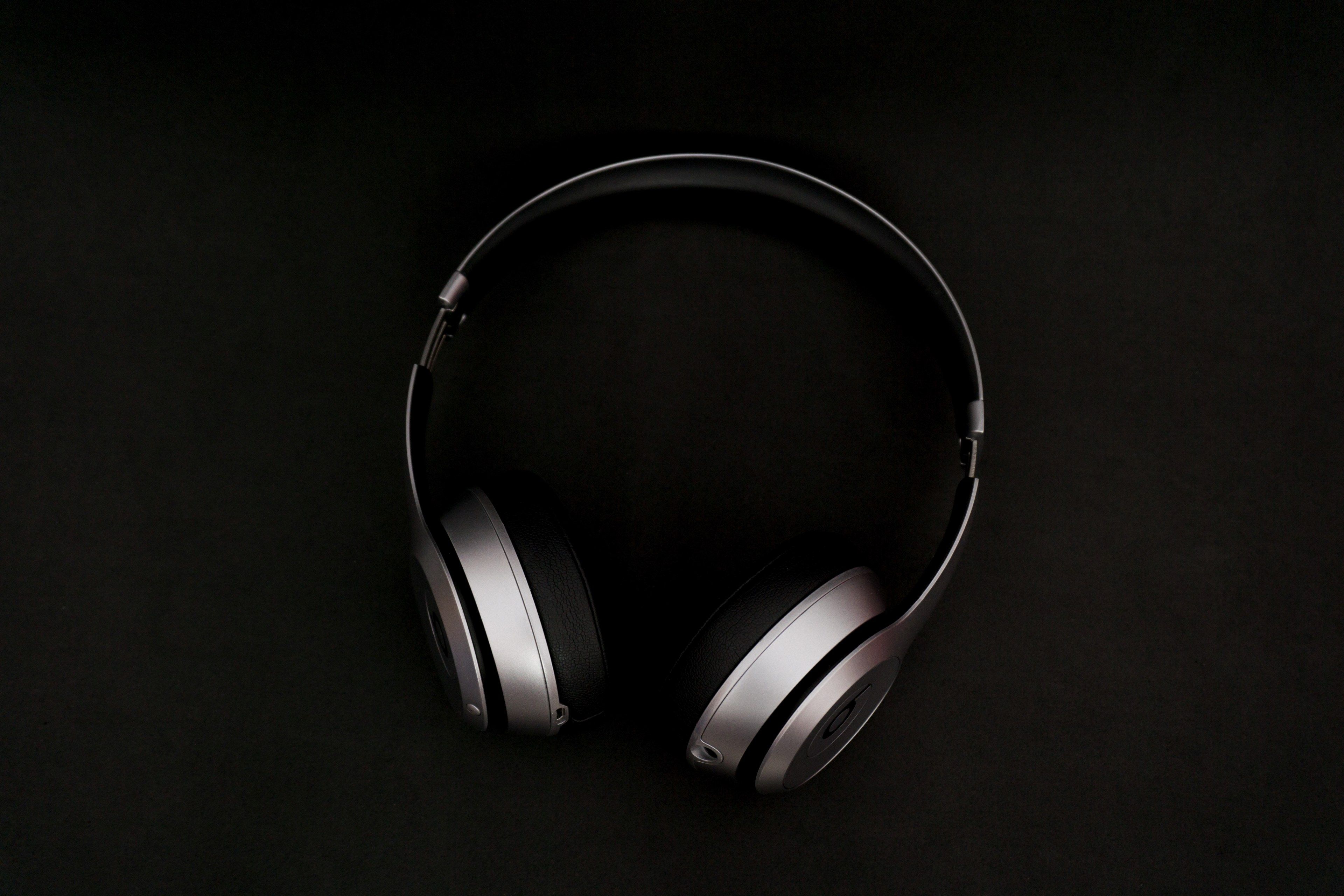 silver and black earphones in black background standing