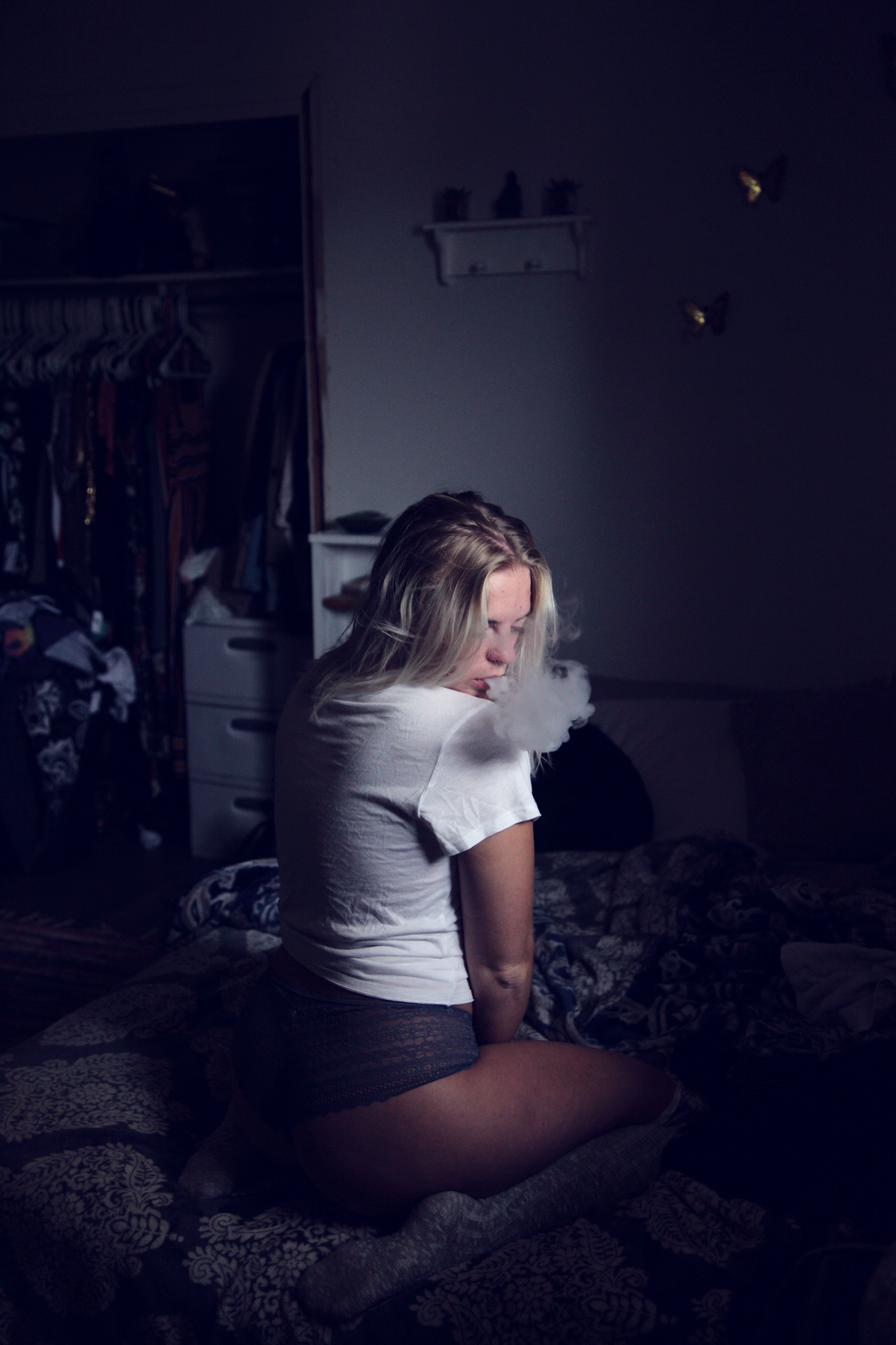 Woman Wearing White Shirt Sitting on Sofa and Smoking · Free Stock