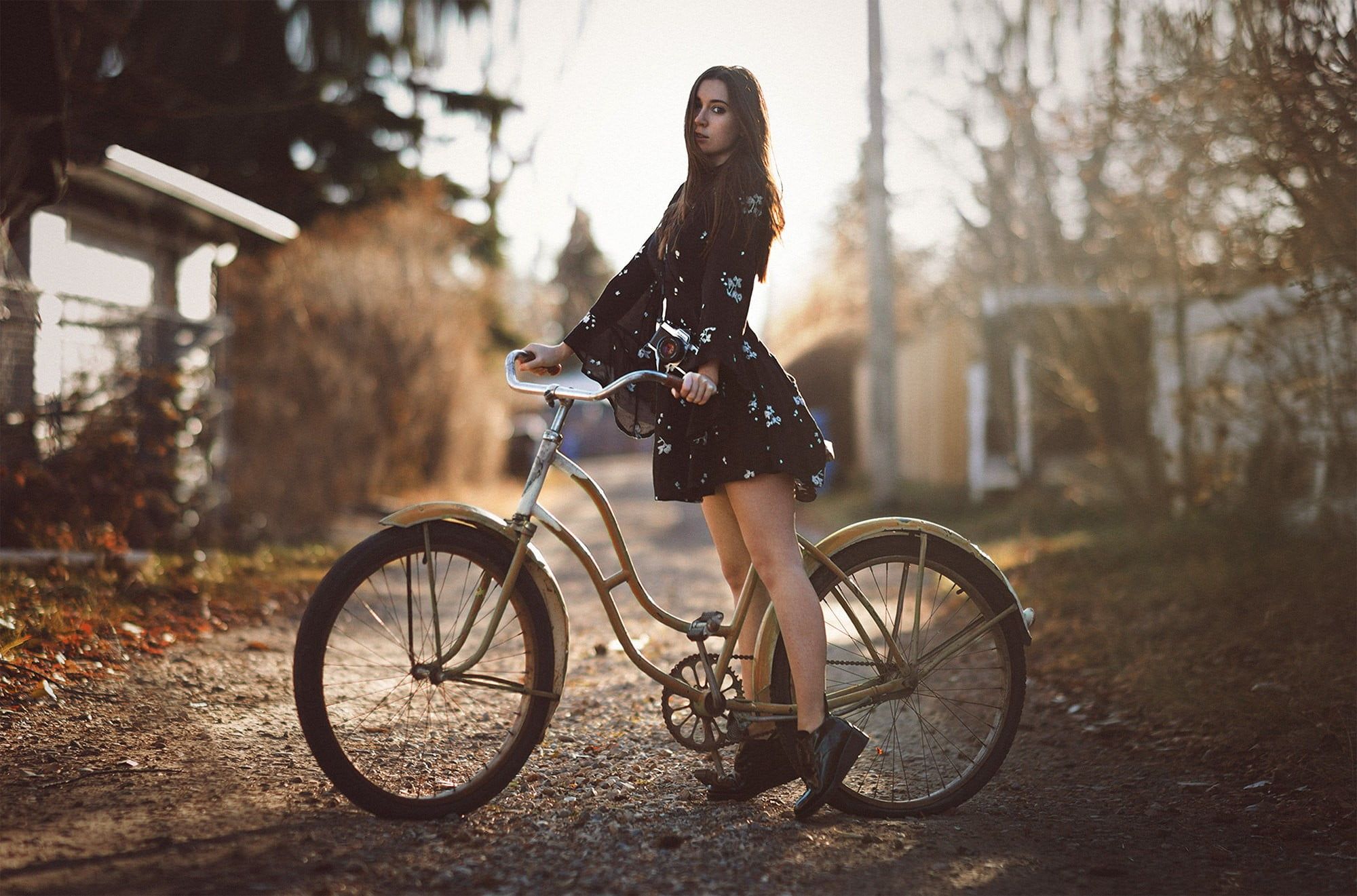 Woman riding on brown beach cruiser bike standing on brown road