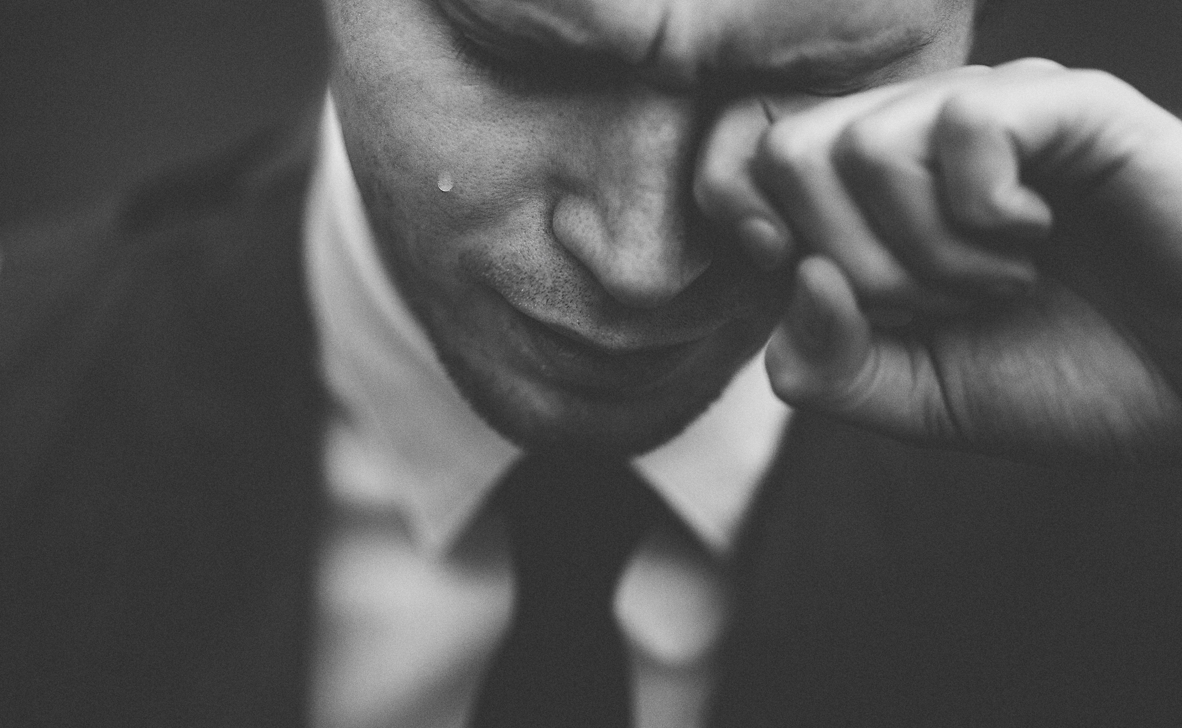 a black and white shot of a crying man in a suit and tieemotion 4k