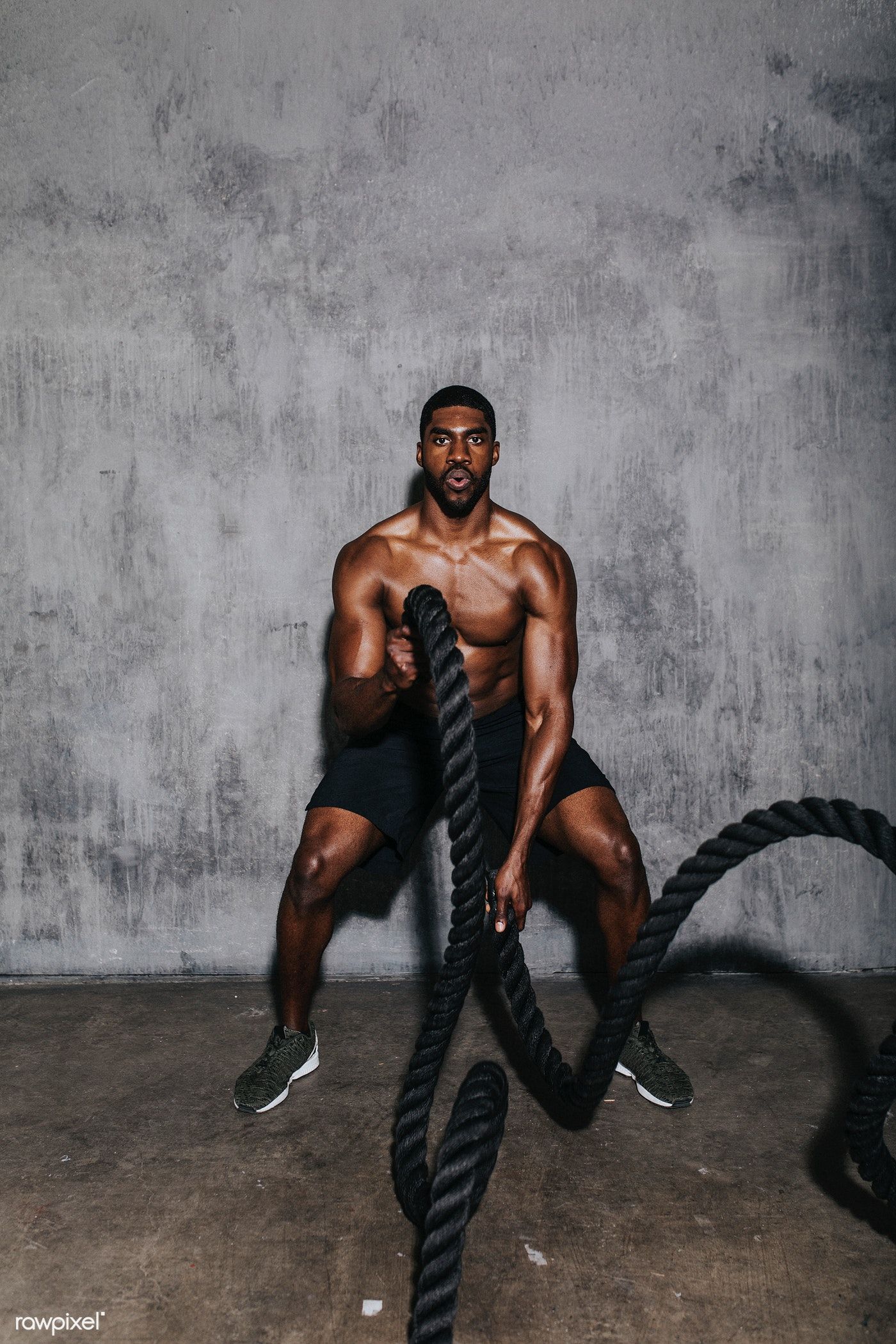 Download premium image of Muscular man doing a battle rope in a