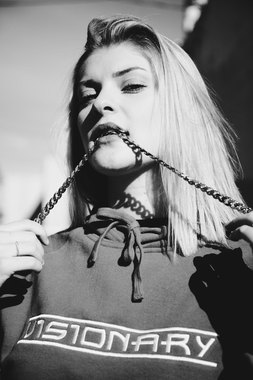 grayscale photography of woman biting rope photo
