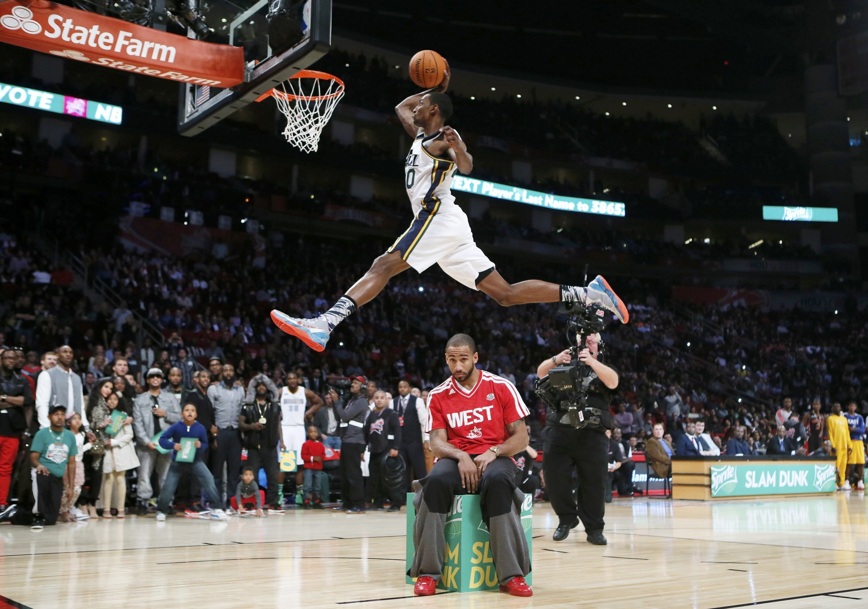 Basketball player in white and black jersey shirt and shorts slam