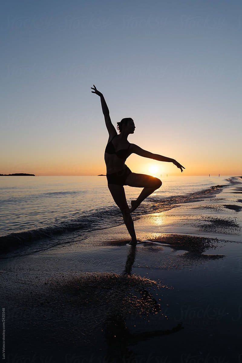 Silhouette Of A Dancer On The Seashore At Sunset.