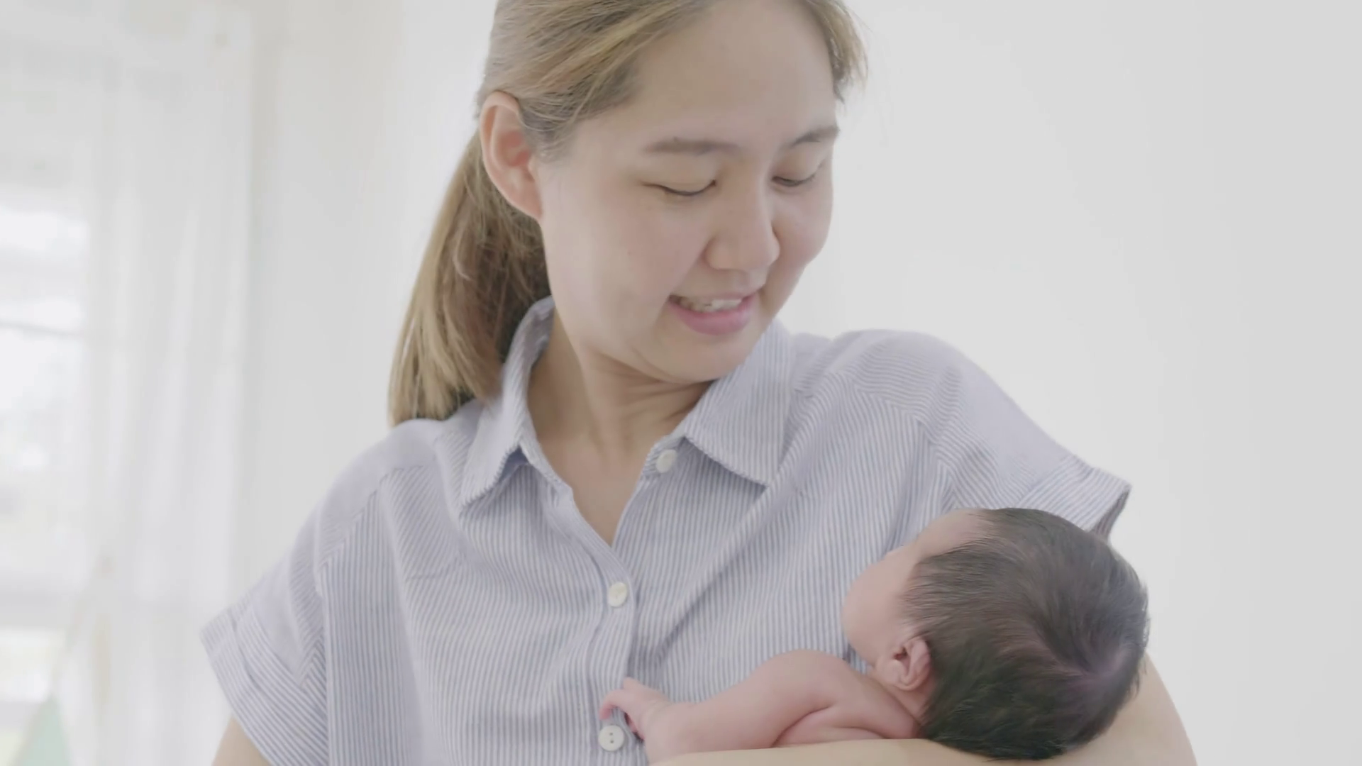 4K Happy Asian mother hugging her newborn baby daughter at home