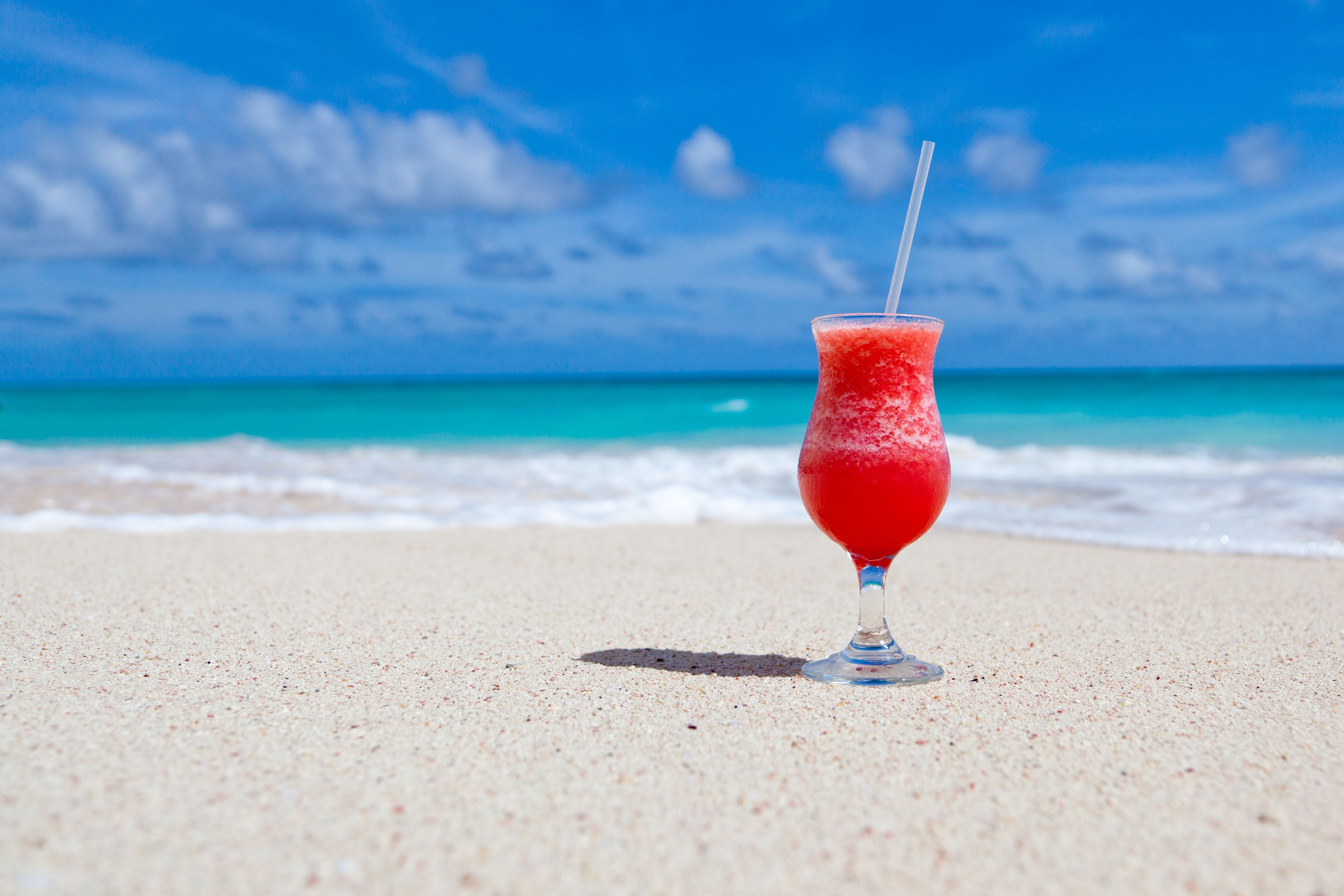 Ice cold red beverage on a caribbean beach 4k Ultra HD Wallpapers