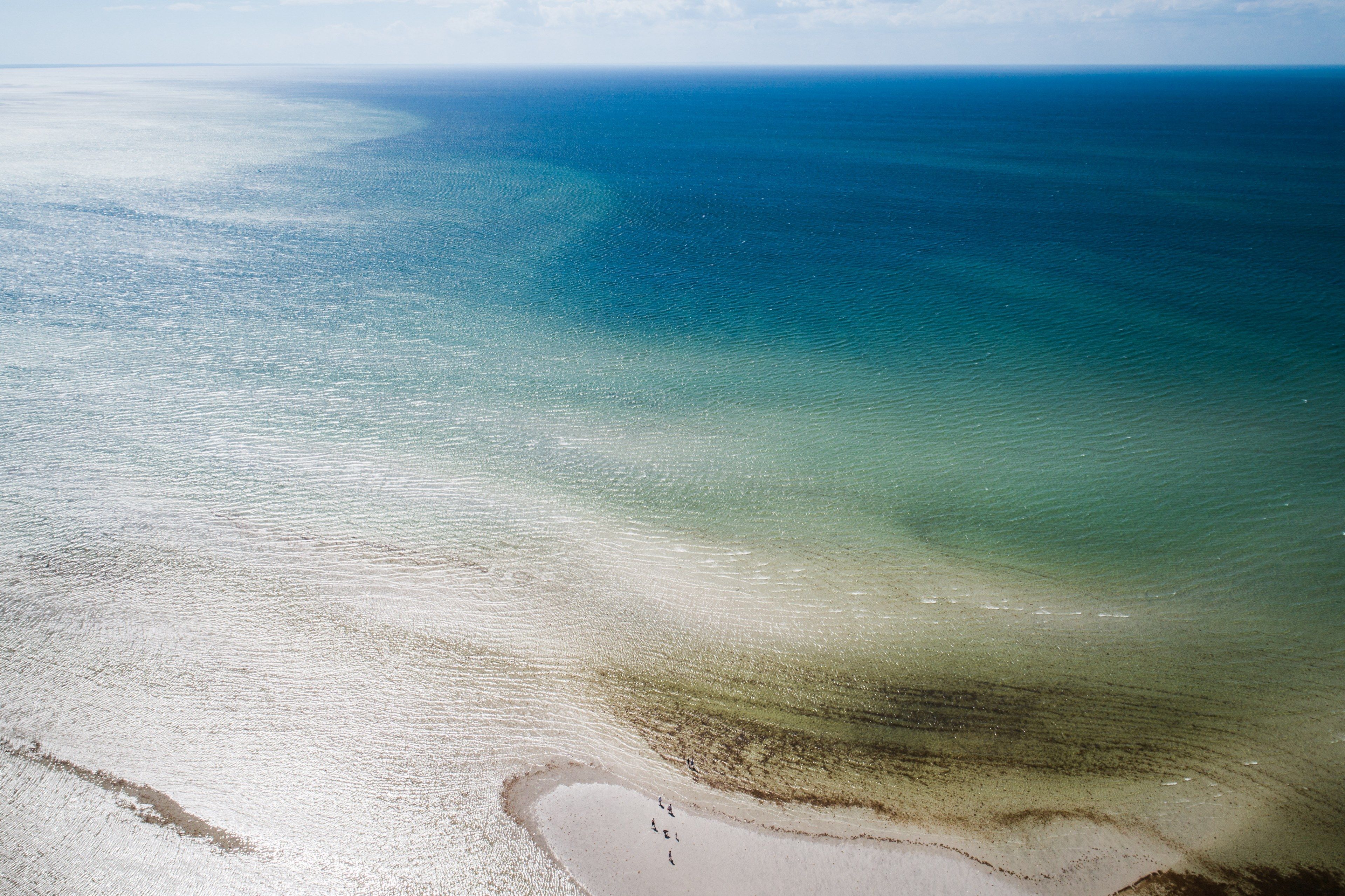 drone aerial view of the shallow waters near a sand beach at