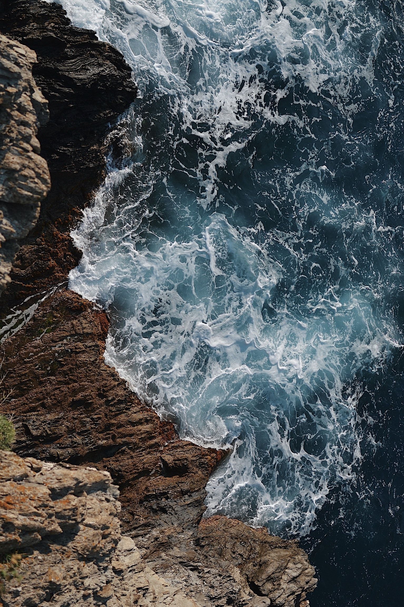 waves splashing on gray rocky cliff during daytime. iPhone