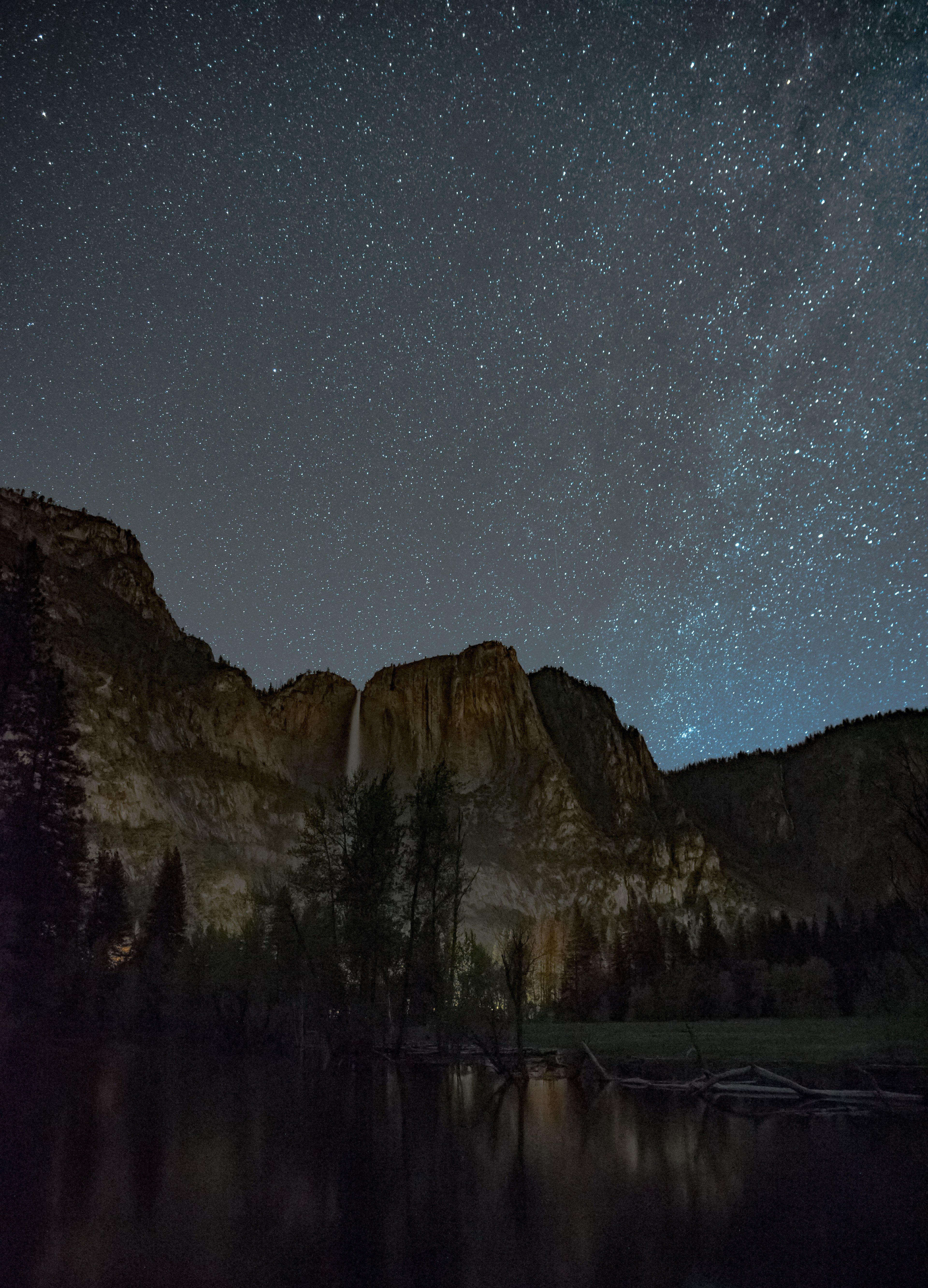 a starry sky above a rocky mountain starry night 4k wallpaper