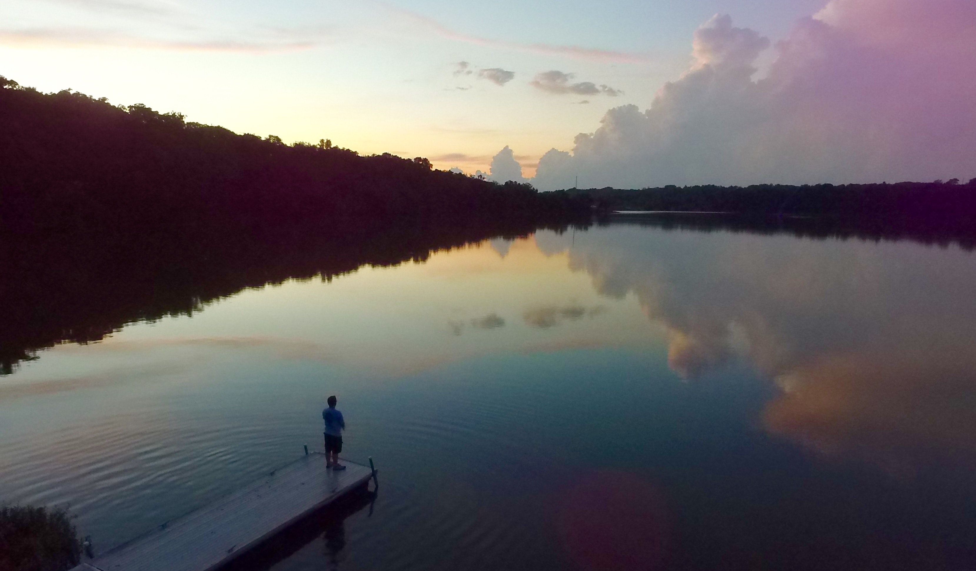 Man Standing on River Dock during Sunset · Free