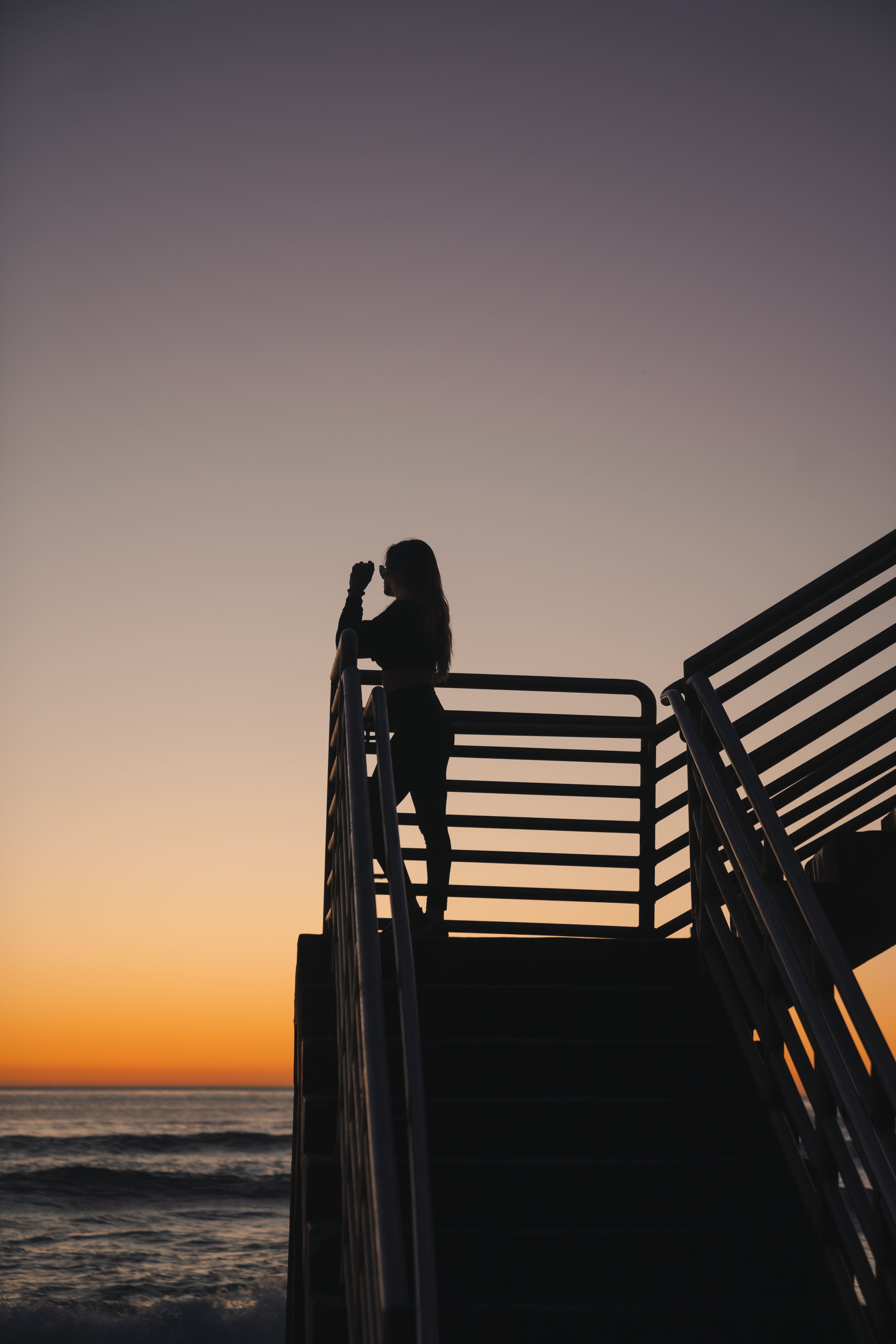 Silhouette Of A Woman Standing on Wooden Dock during Sunset · Free