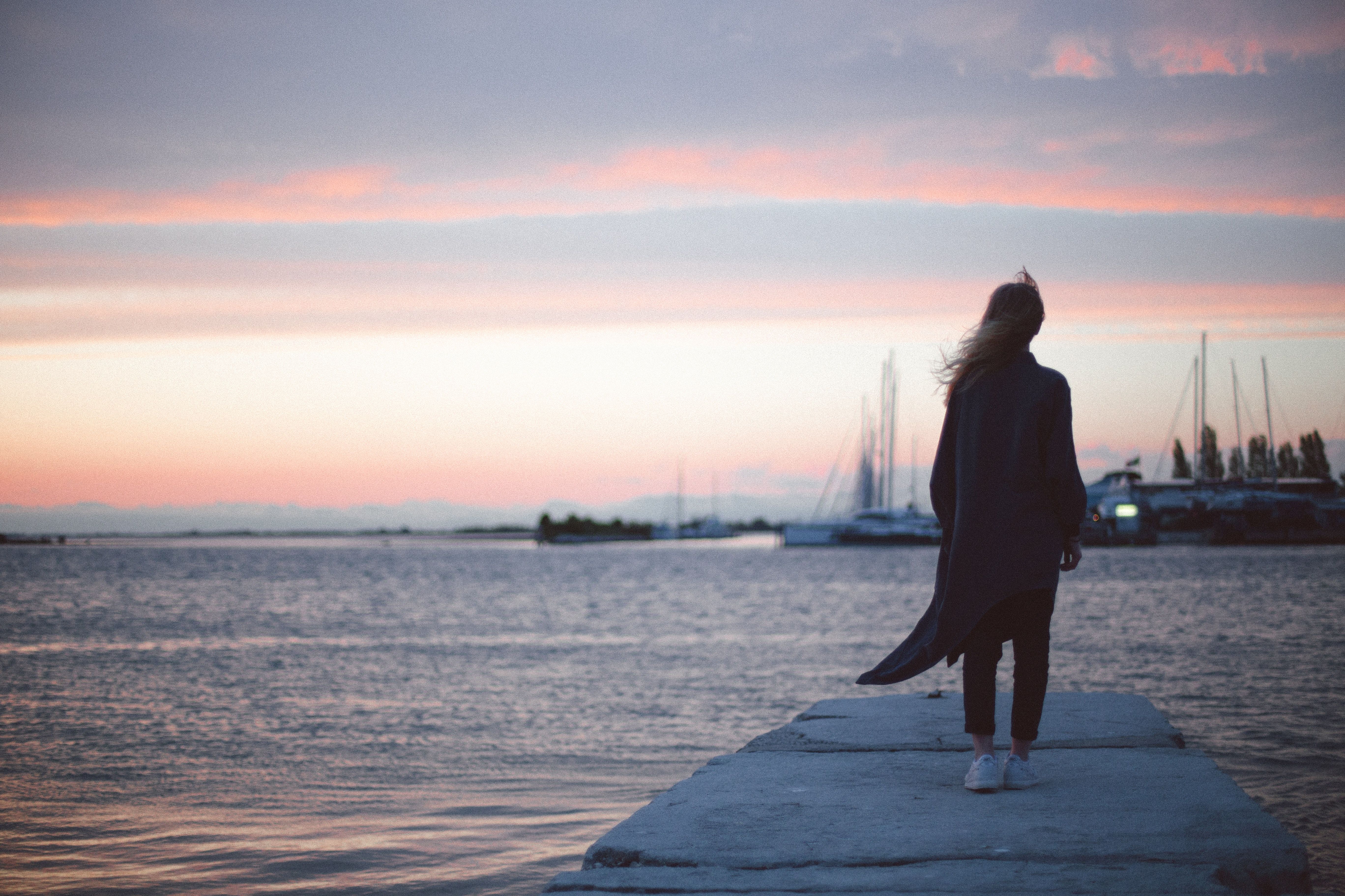 Woman Standing on a Dock during Sunset · Free