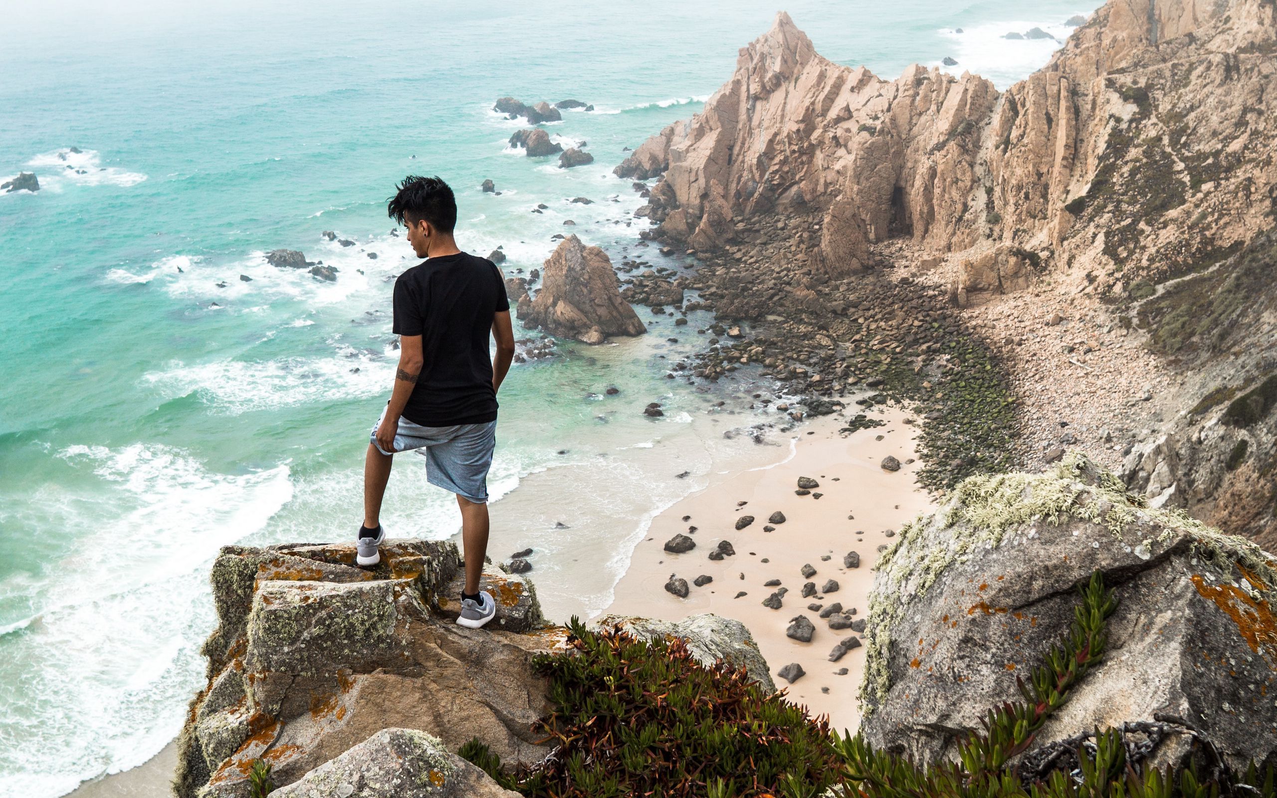 Download wallpaper 2560x1600 cliff, man, rocks, sea, beach