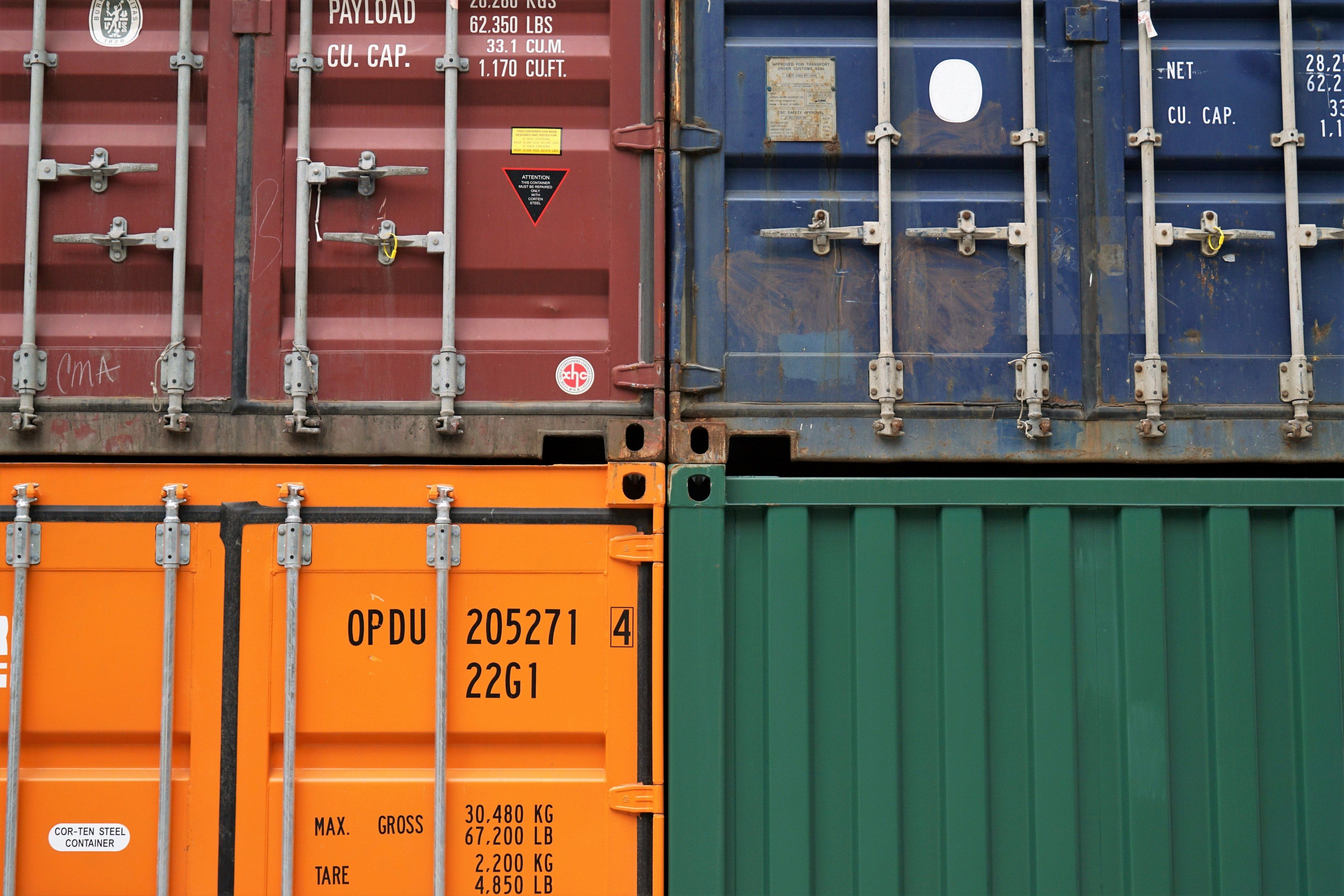 close up of four shipping containers in various colors stacked