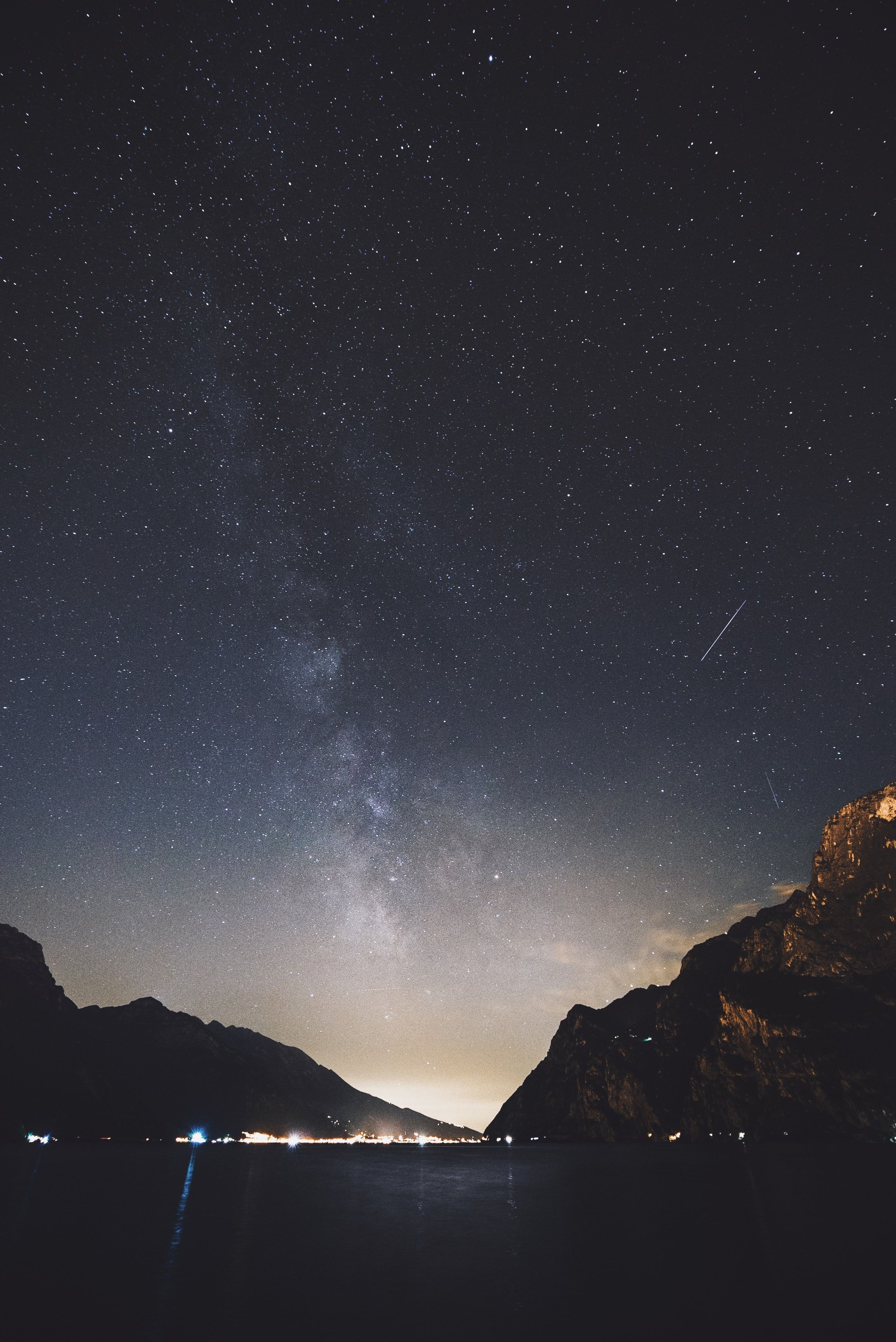 The milky way and a shooting star over the lake and mountain at