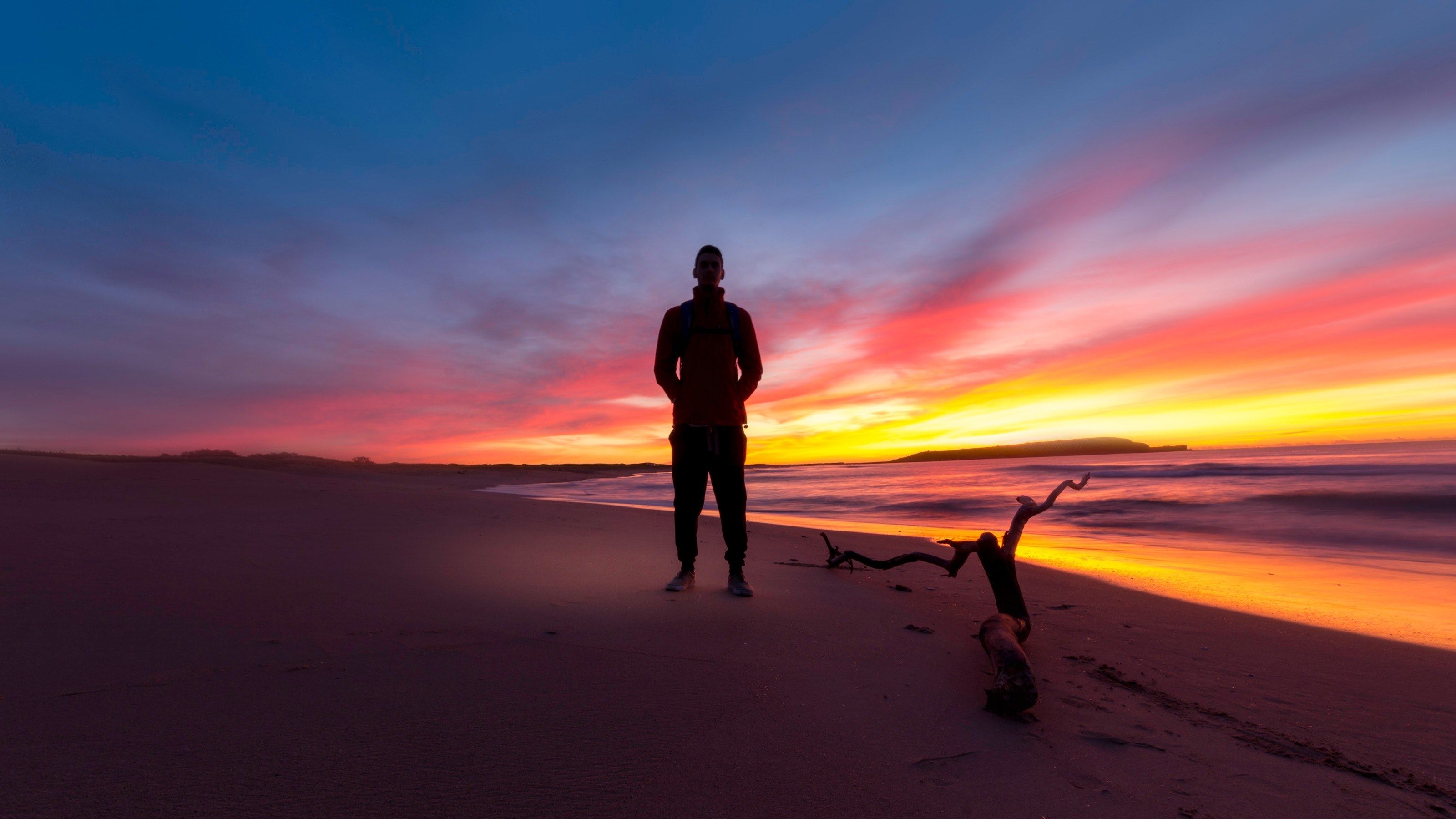 a male silhouette on a sydney beach during the late evening with a