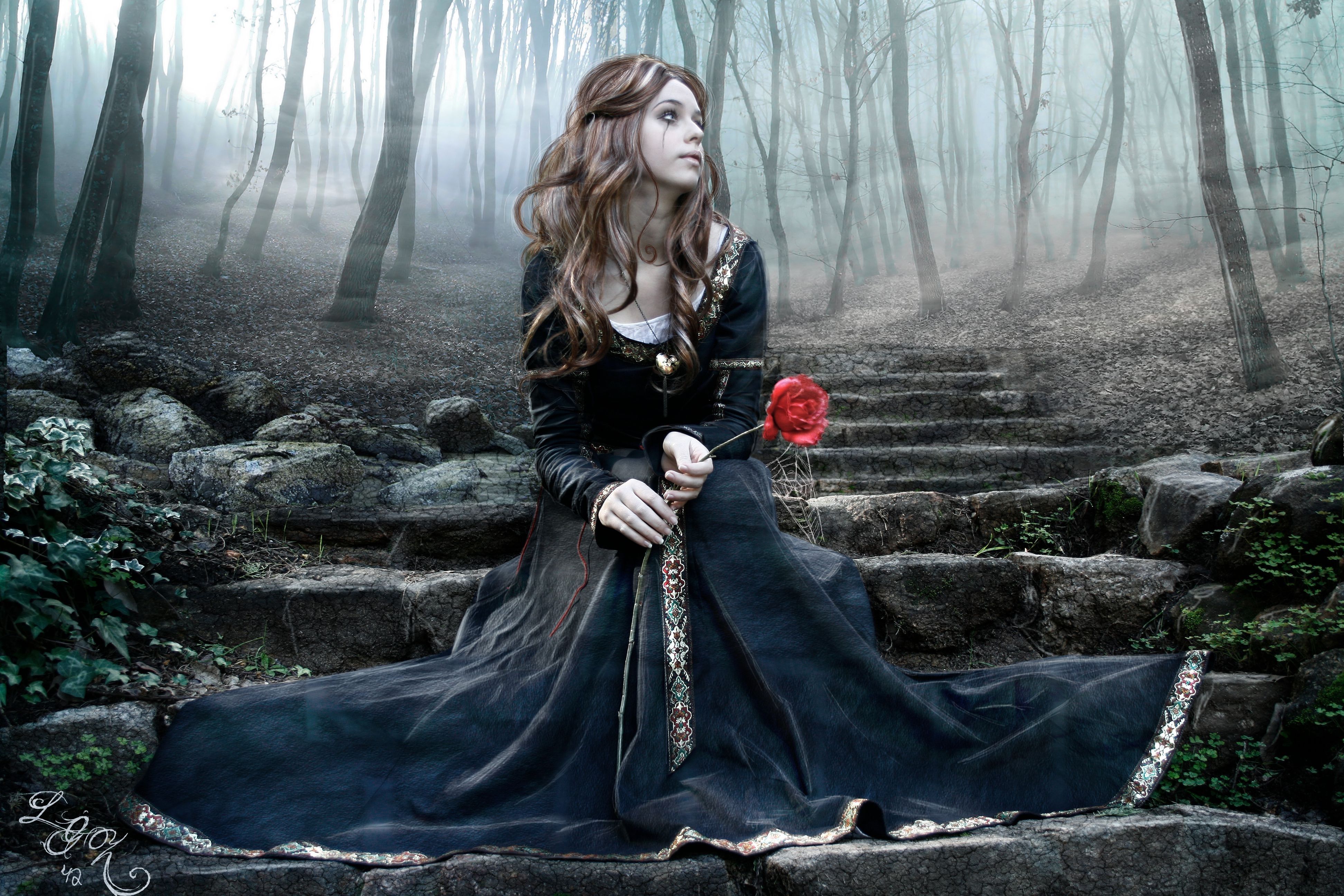 Goth Woman in a Long Black Dress Sitting on Stairs in a Foggy