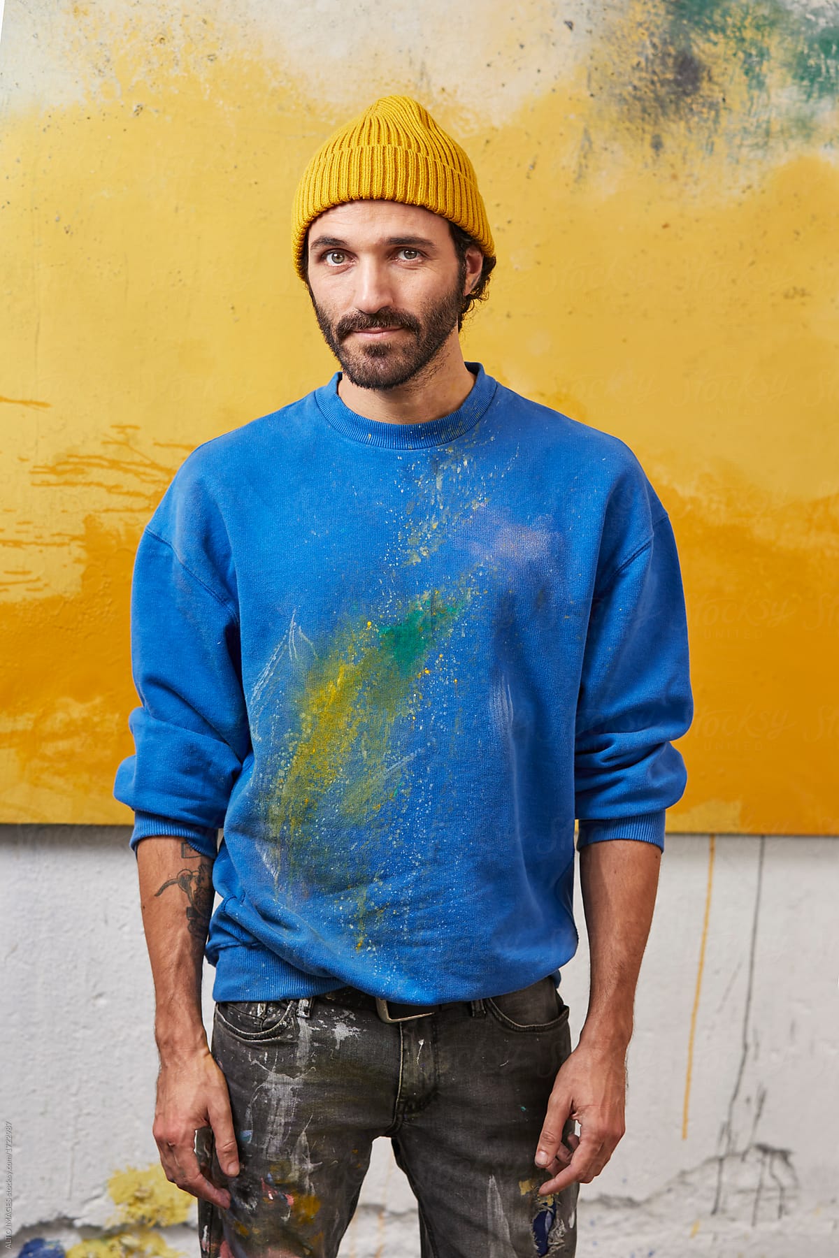 Male Painter In Messy Casuals Against Painting In Studio