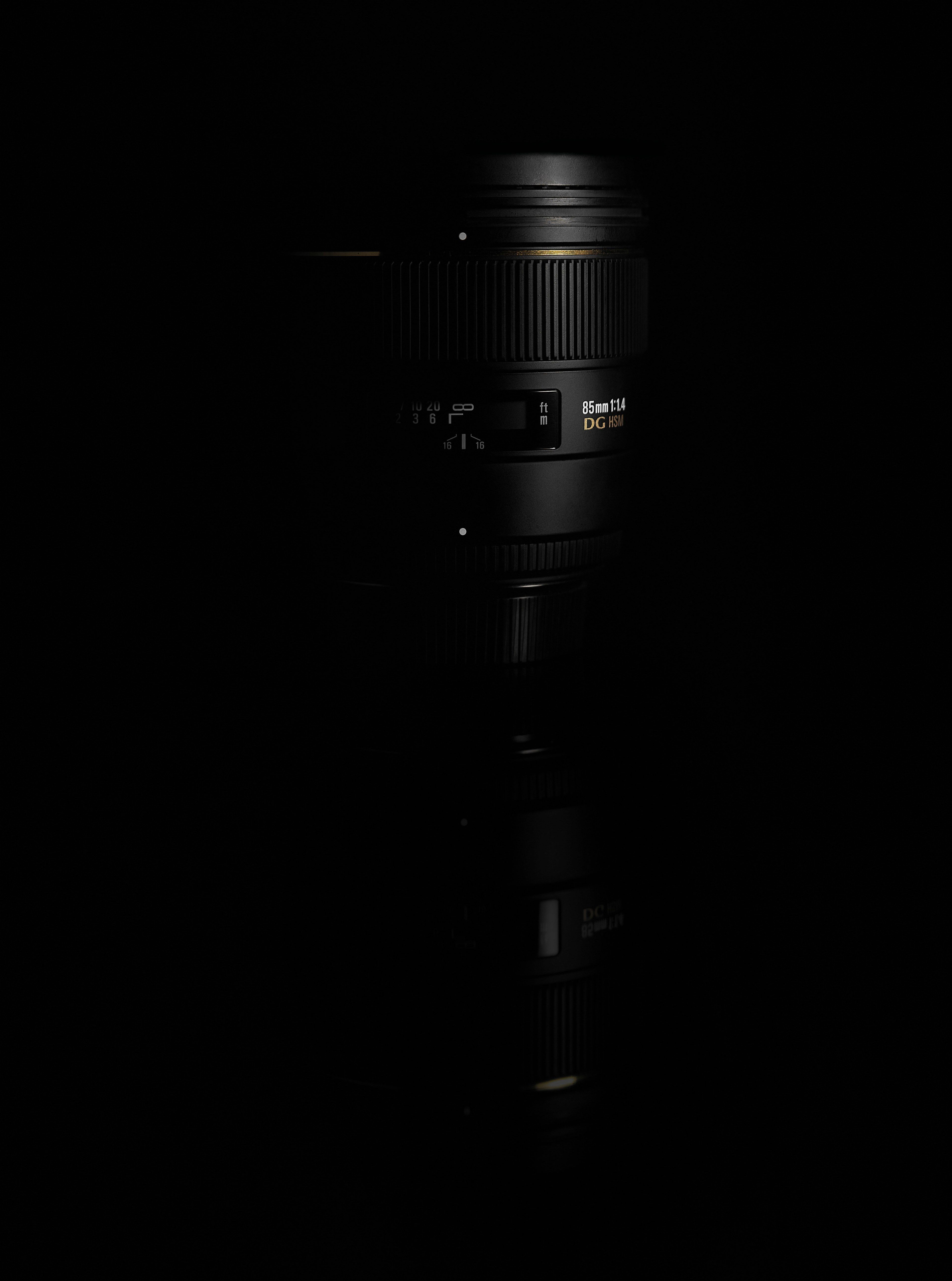Wallpaper / black 85mm dslr camera lens on a black
