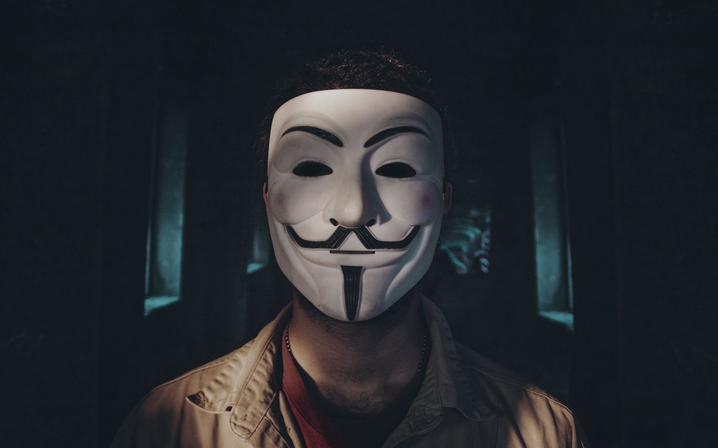 Download wallpaper 1440x900 man, mask, anonymous, shadow, dark