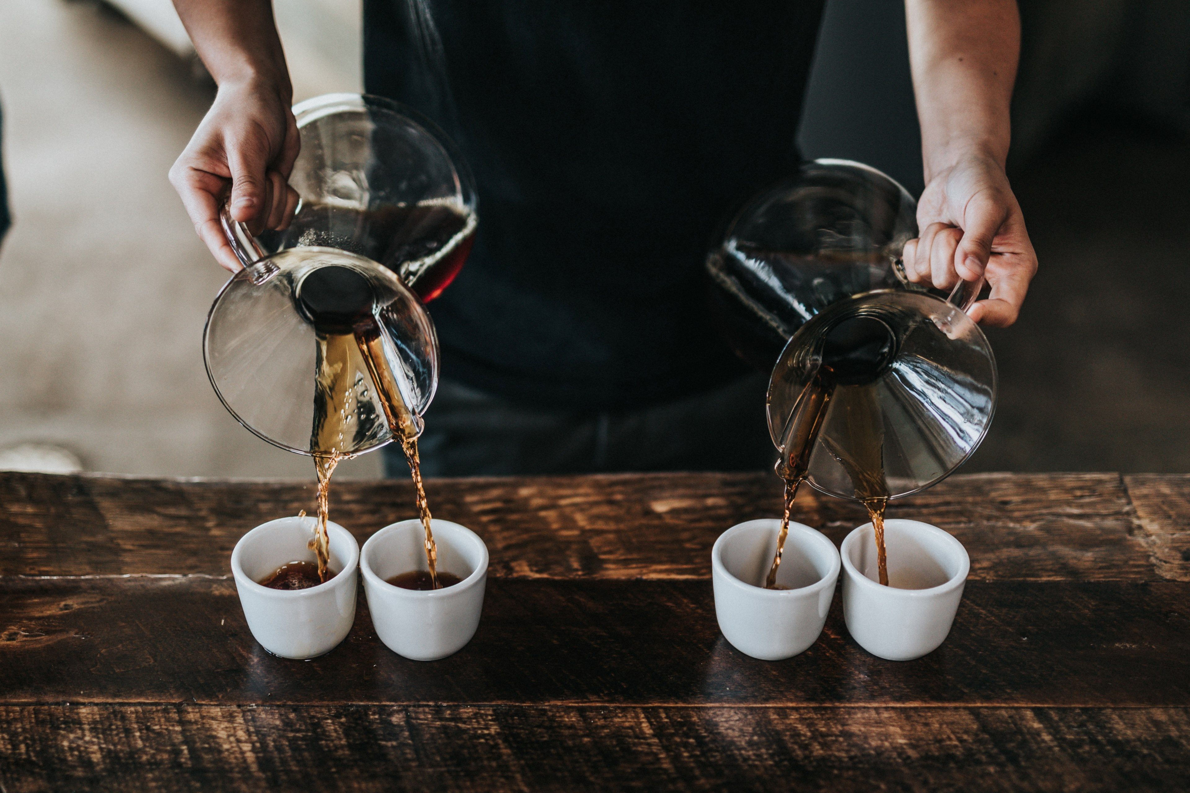 Wallpaper / a barista pouring coffee to four cups at