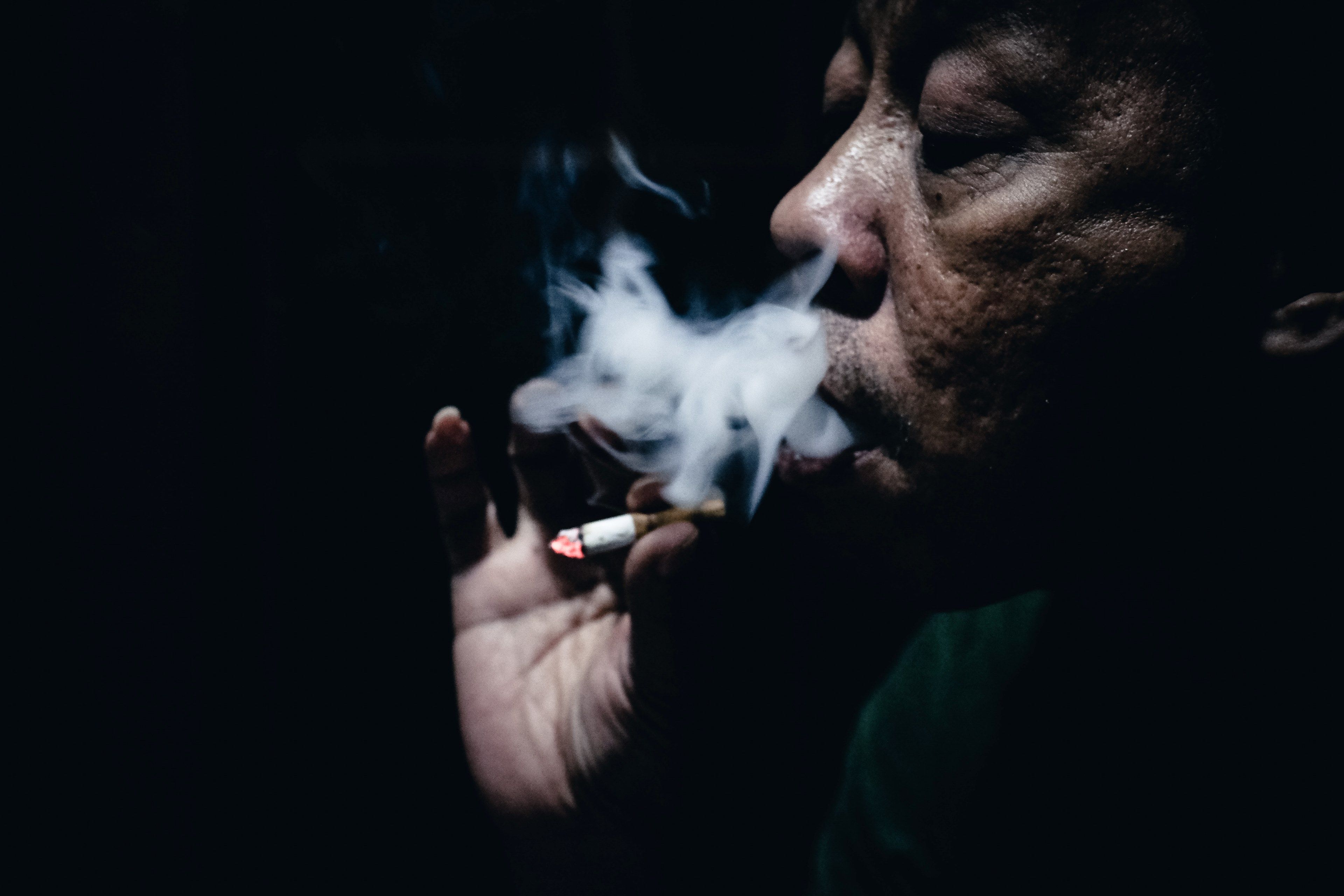 Wallpaper / dark skinned old man smoking a cigarette in the dark, i smoke therefore i am_ 4k wallpaper