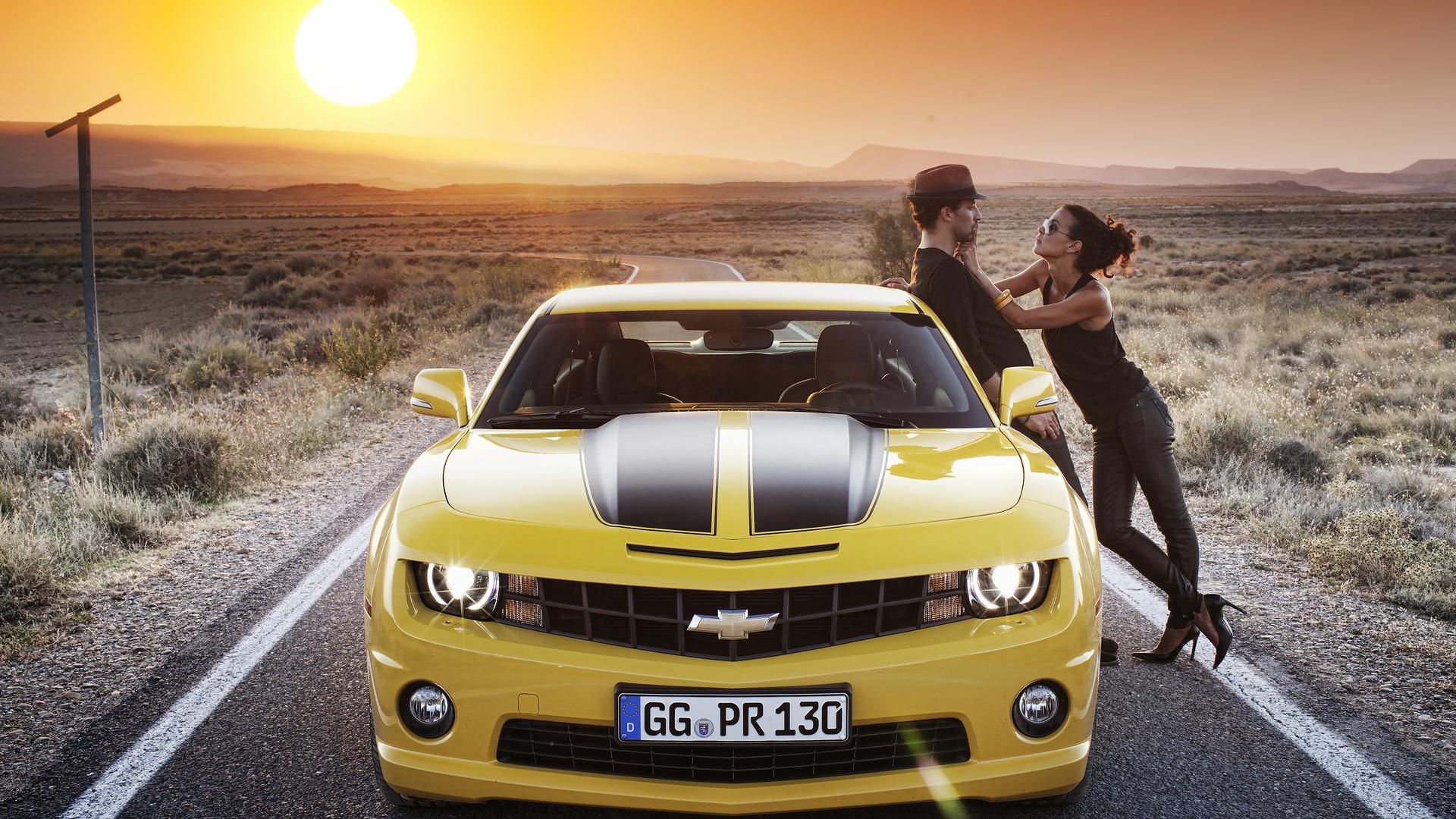 Couple leaning on the Chevrolet Camaro HD desktop wallpaper