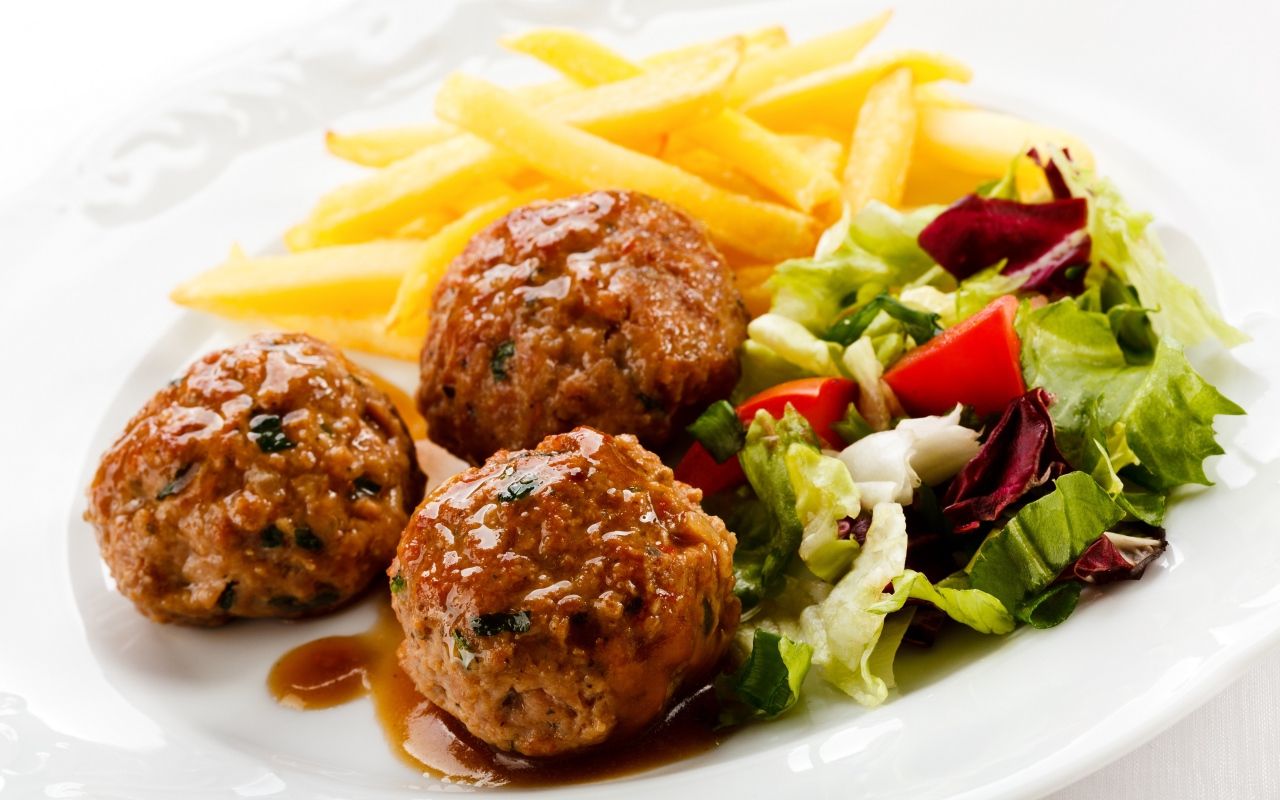 Meatballs with french fries and salad on a white plate Desktop