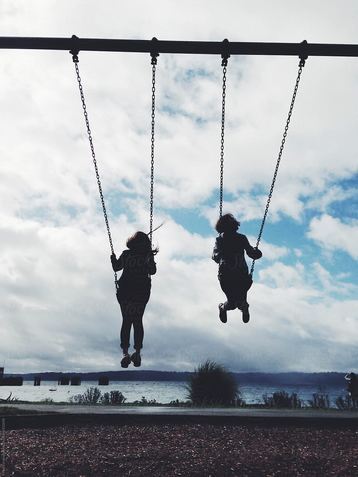 Silhouette of two girls on swing