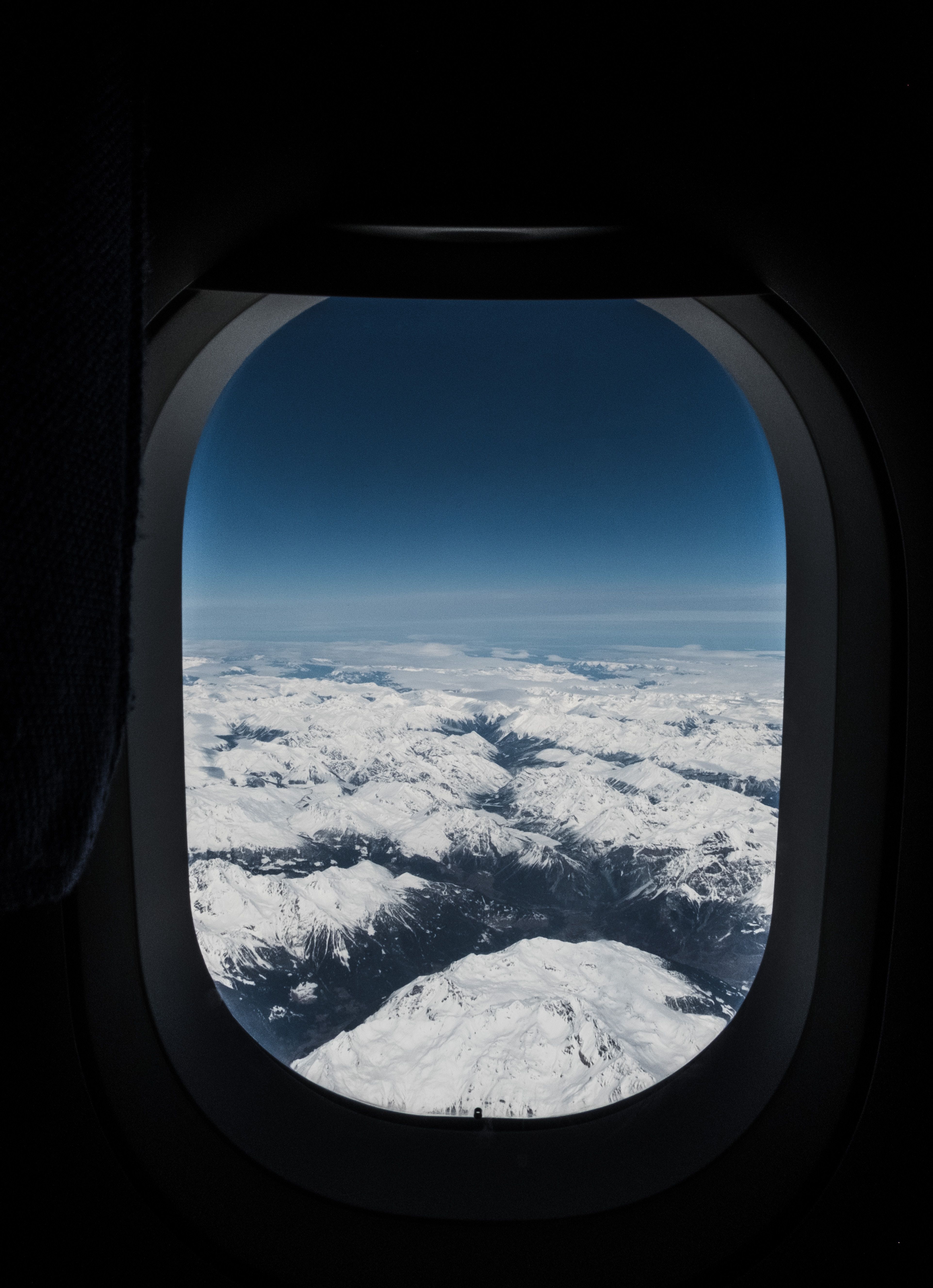 Download wallpaper 3846x5310 porthole, airplane window, mountains, aerial view, flight, sky, peaks HD background